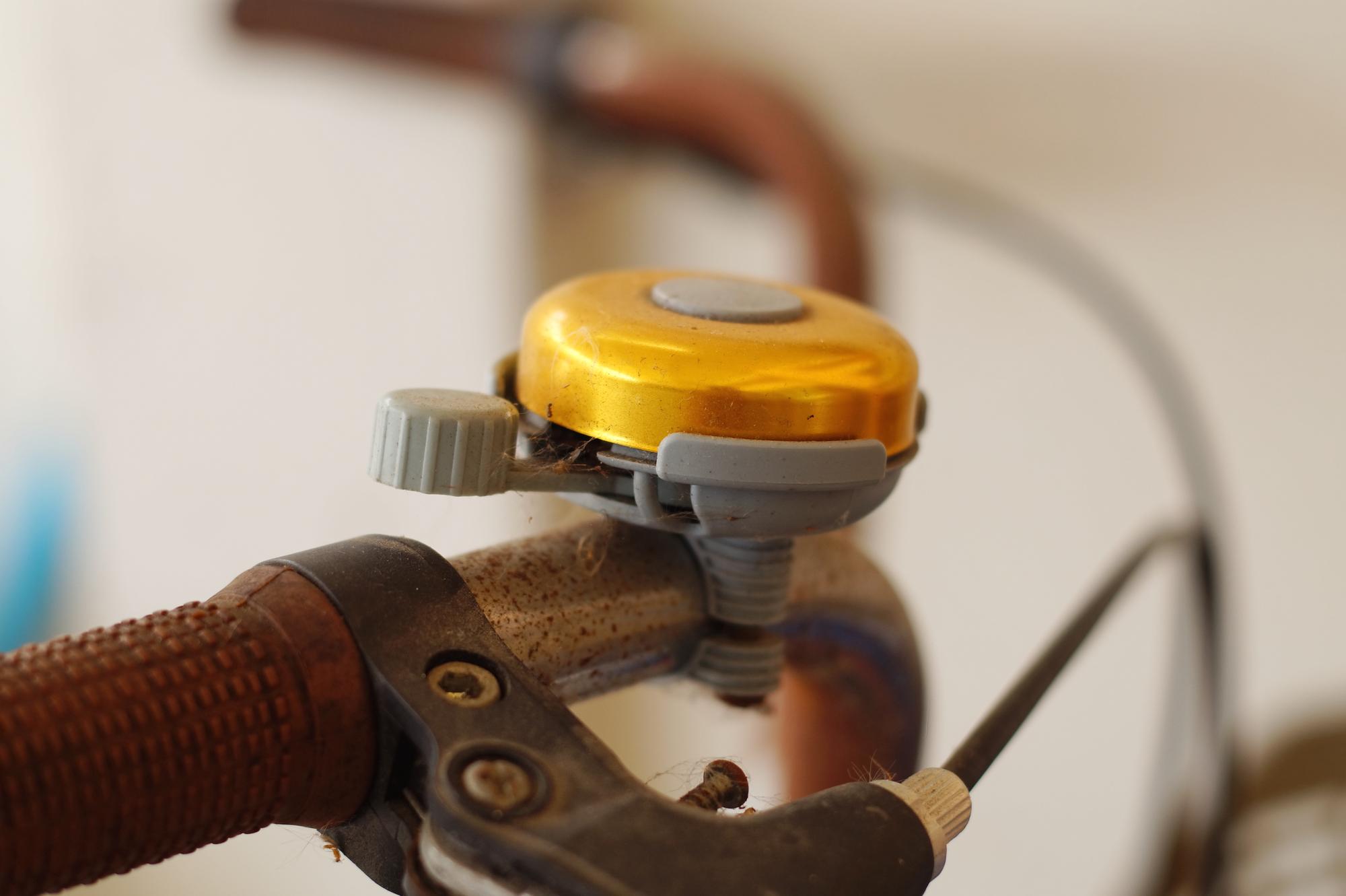 Close-up de um sino dourado no leme enferrujado