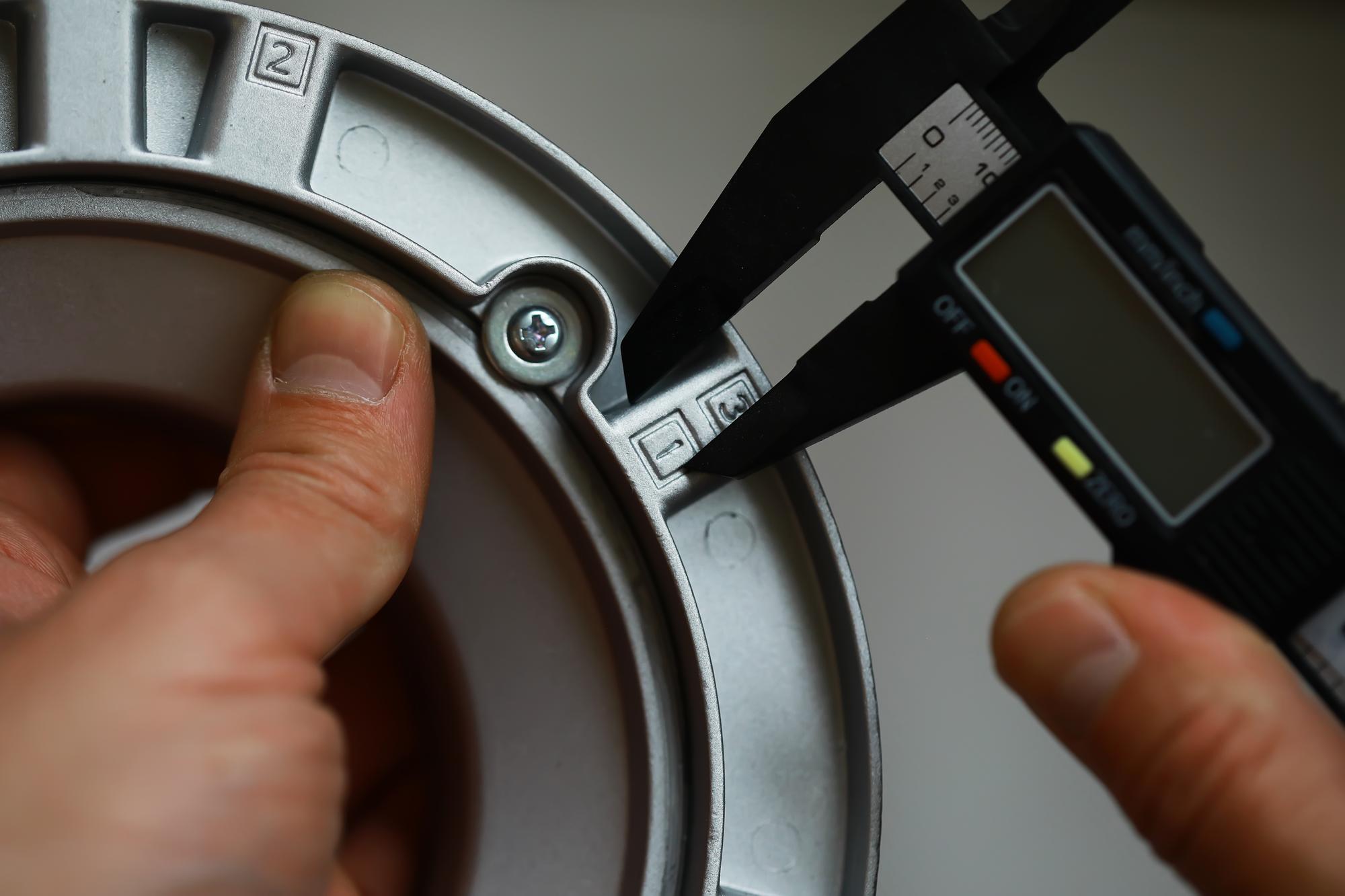 Mãos Medindo Peça de Metal com Paquímetro Digital para Engenharia de Precisão e Controle de Qualidade