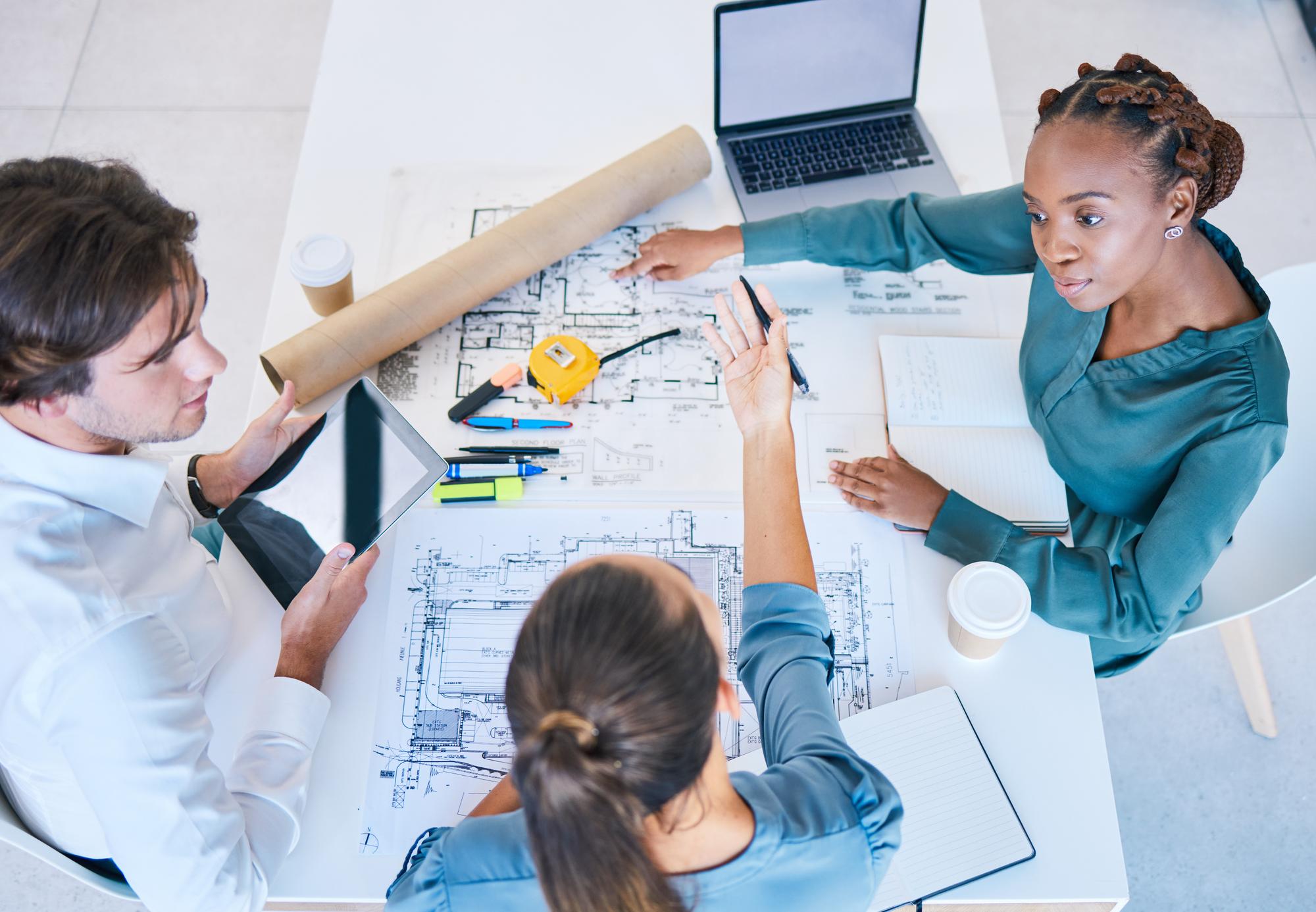 Planejamento de trabalho em equipe e discussão de arquitetos trabalhando em uma nova casa de construção ou vista superior de design de shopping center Colegas de equipe ou força de trabalho com projetos de plantas e planos para um projeto da empresa