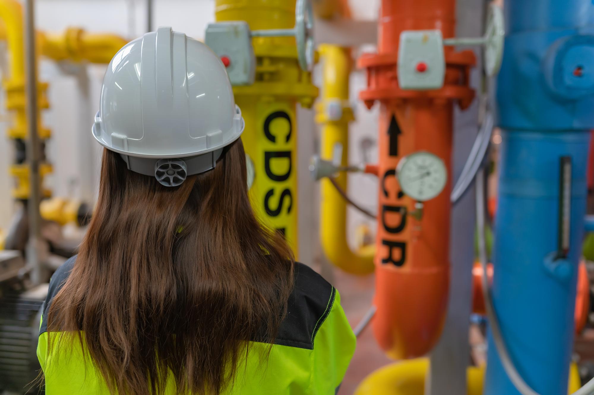 Engenheiro asiático usando óculos trabalhando na manutenção da sala da caldeira verificando dados técnicos do equipamento do sistema de aquecimentoTailândia