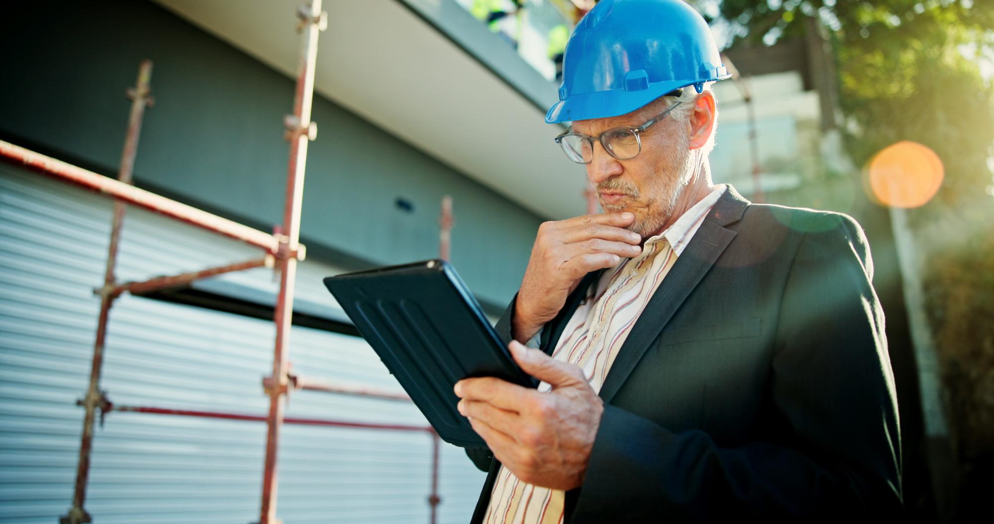 Homem em canteiro de obras pensando, com tablet, checklist online e rede com cronograma. Arquiteto maduro e funcionário com capacete, tecnologia e conexão para inspeção e segurança.
