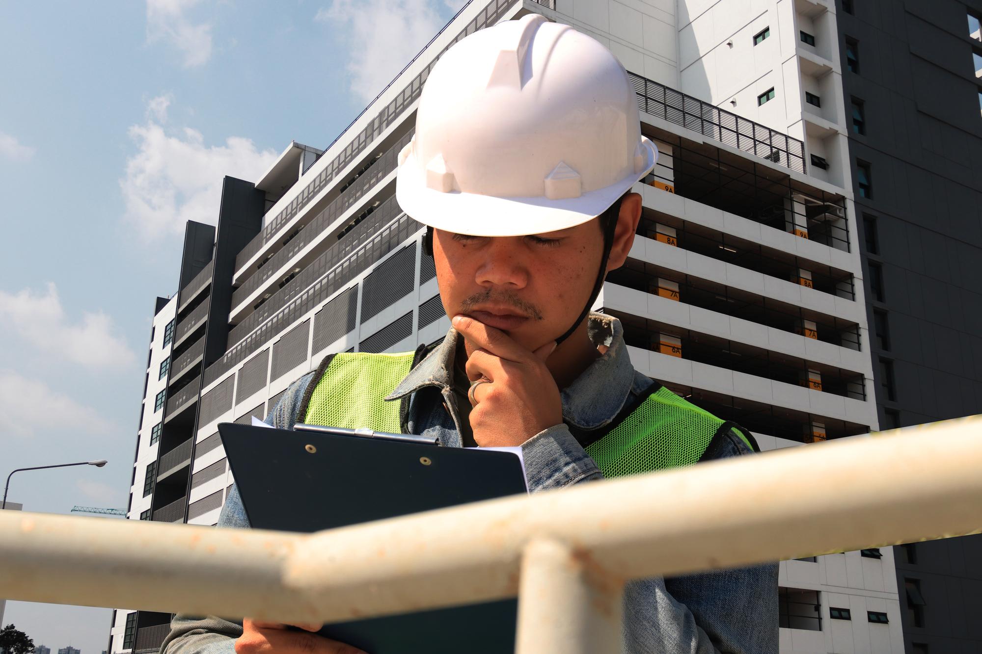 Trabalhadores da construção civil segurando tábuas para escrever trabalho