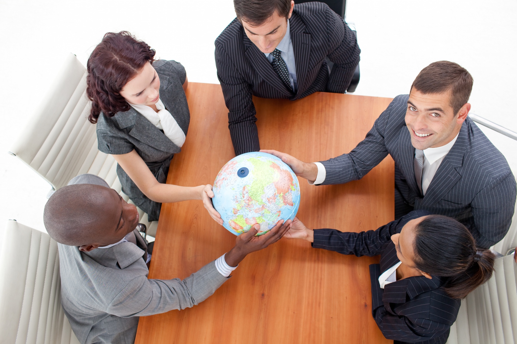 Executivos em uma sala de reuniões moderna analisando um mapa-múndi digital em uma tela de alta tecnologia, simbolizando a expansão internacional e a consultoria estratégica.