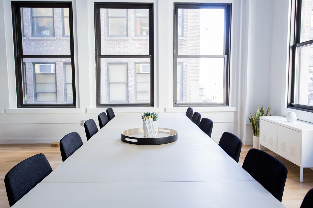 Executivos em uma sala de reuniões moderna discutindo estratégias de expansão e gráficos de crescimento em tons de roxo e cinza.
