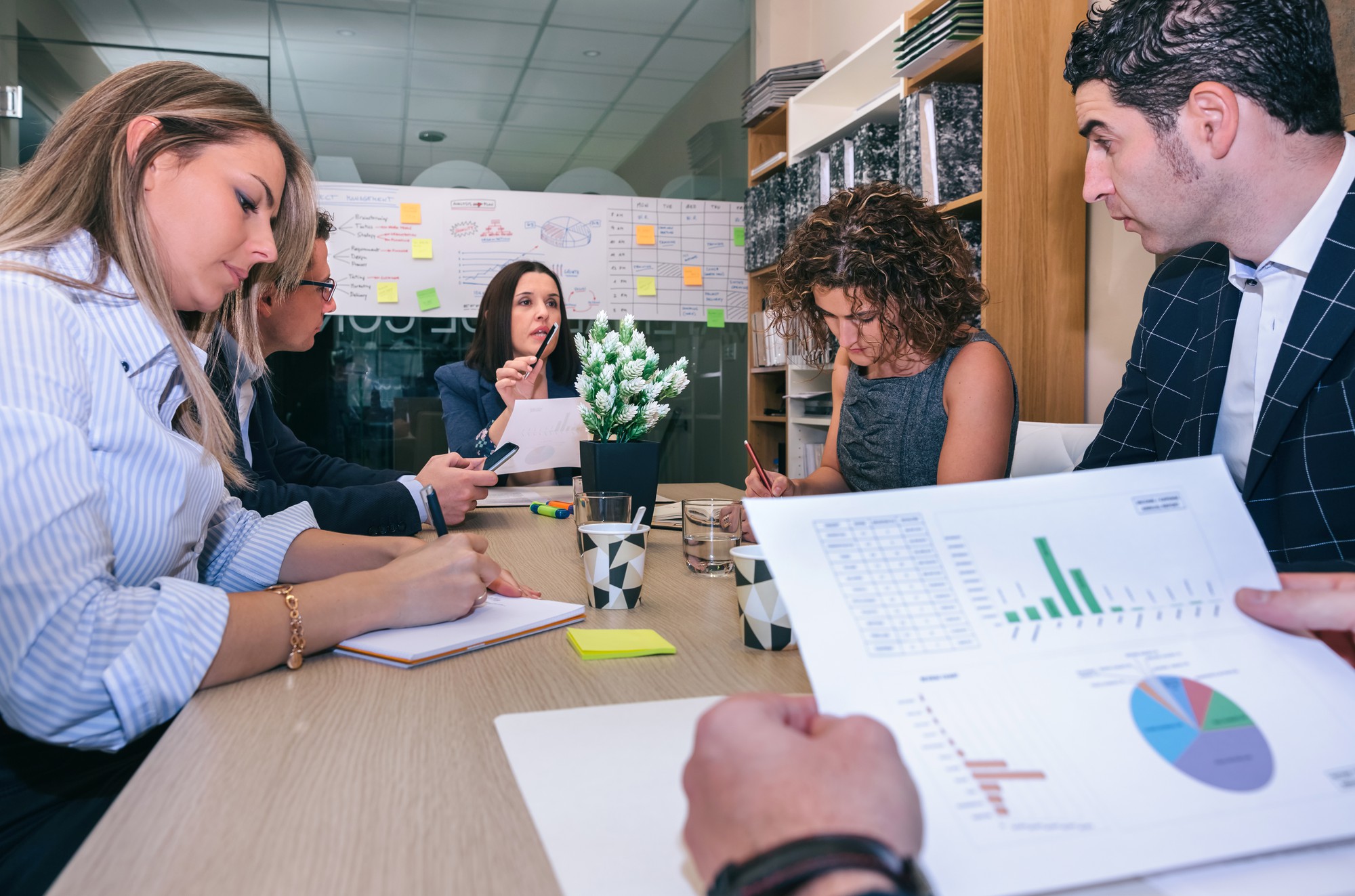 Equipe de gestão estratégica em reunião discutindo integração de sistemas e dashboards de performance