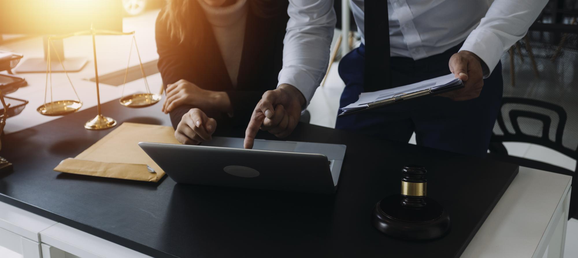 Advogado masculino que trabalha com documentos contratuais e martelo de madeira na mesa no conceito de juiz de justiça e advogado de tribunal