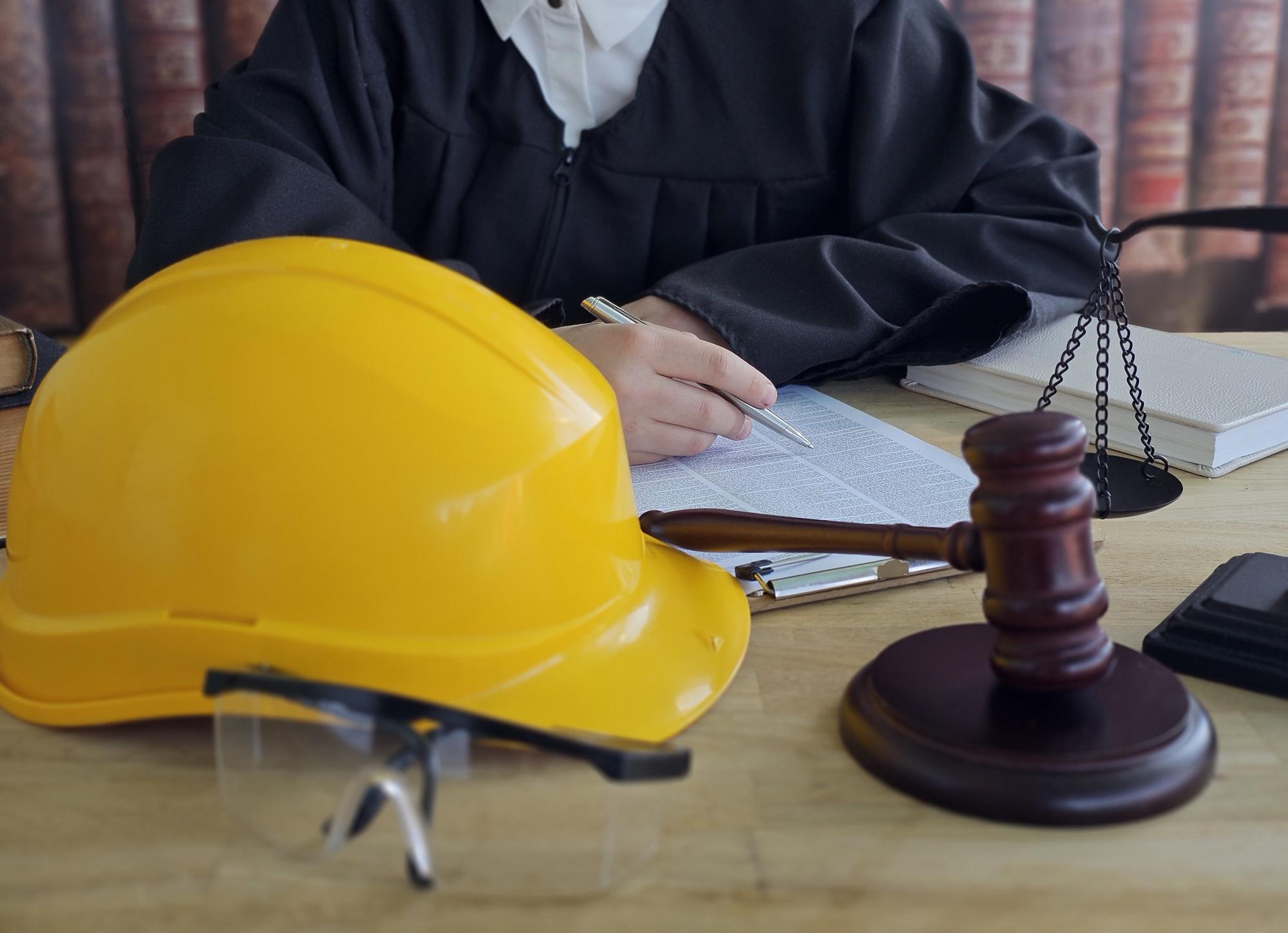 Martelo de juiz e capacete. Lei e Justiça sobre o conceito de direito do trabalho