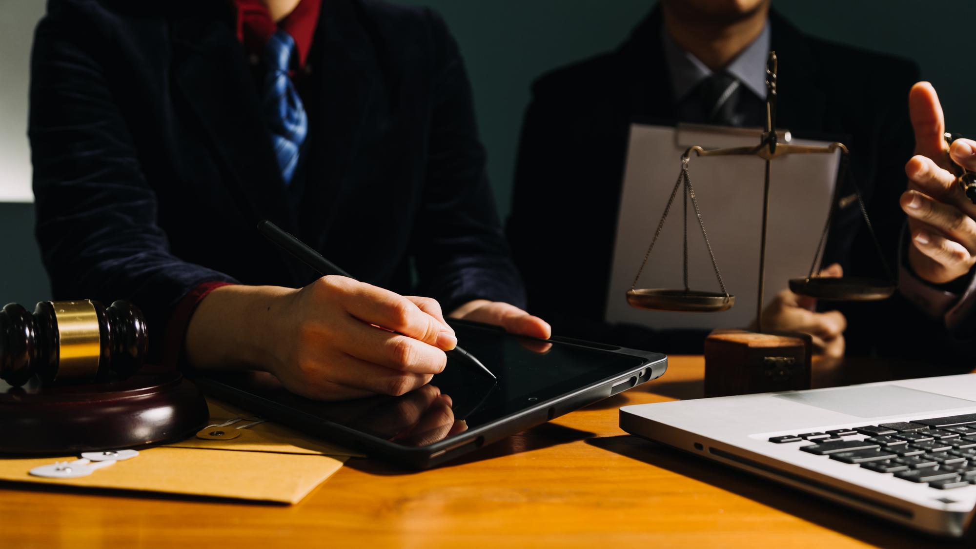 Negócios e advogados discutindo papéis de contrato com escala de latão na mesa no escritório Serviços jurídicos de Direito aconselhamento justiça e direito conceito de imagem com efeito de grão de filme