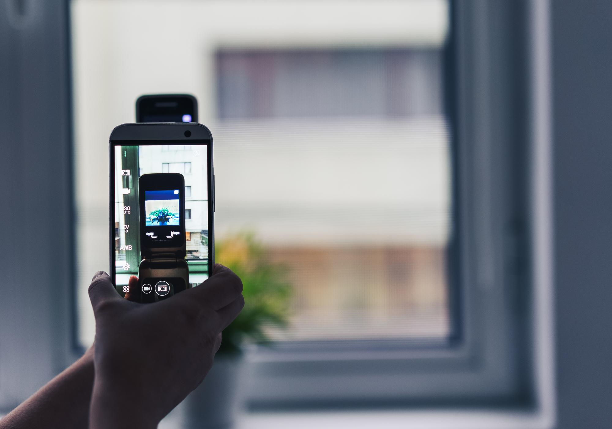 Pai de família visualizando imagens das câmeras de segurança em seu smartphone de forma tranquila, demonstrando facilidade de uso e controle remoto.
