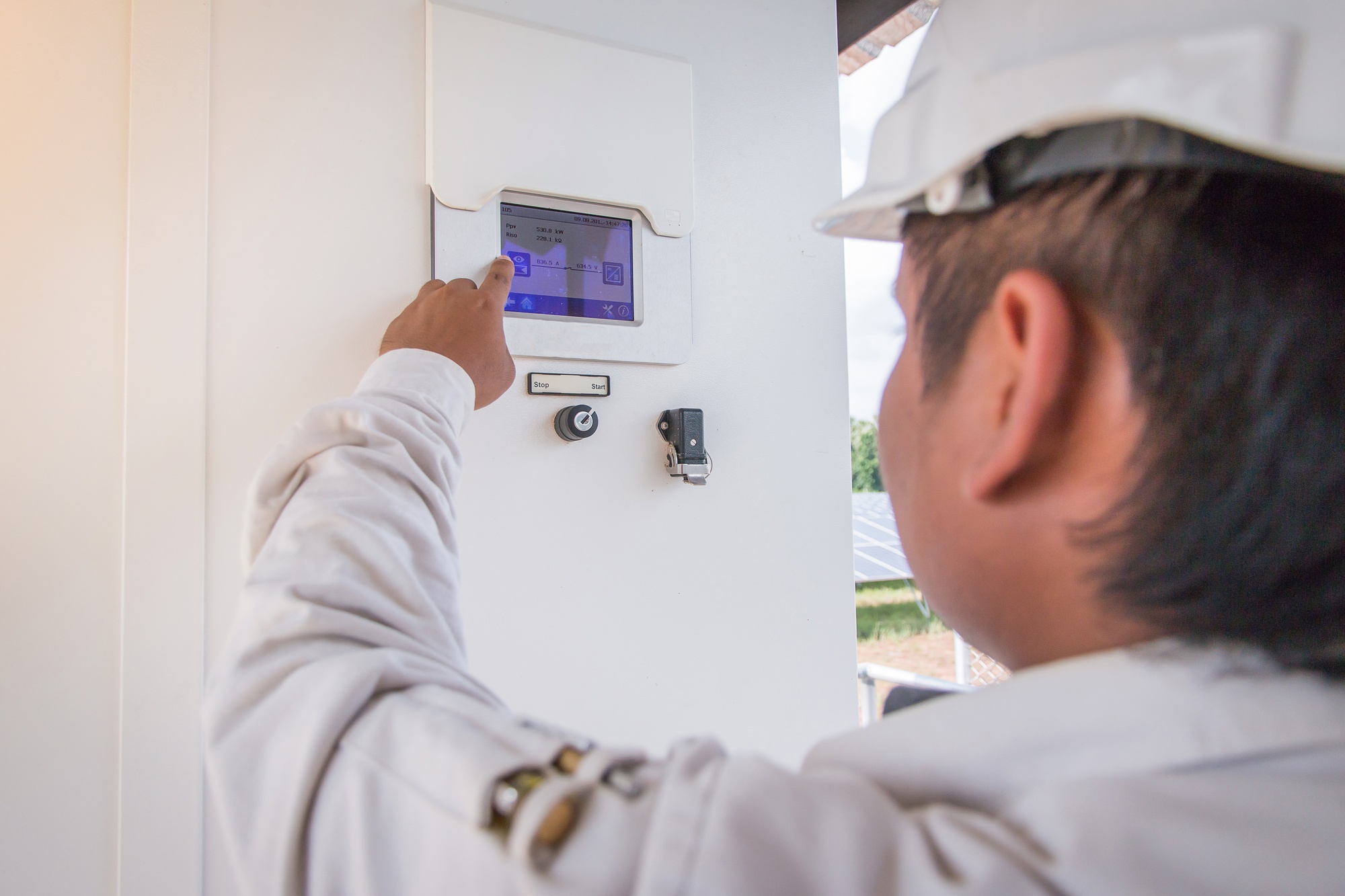 um engenheiro que trabalha na verificação de equipamentos em usina de energia solar