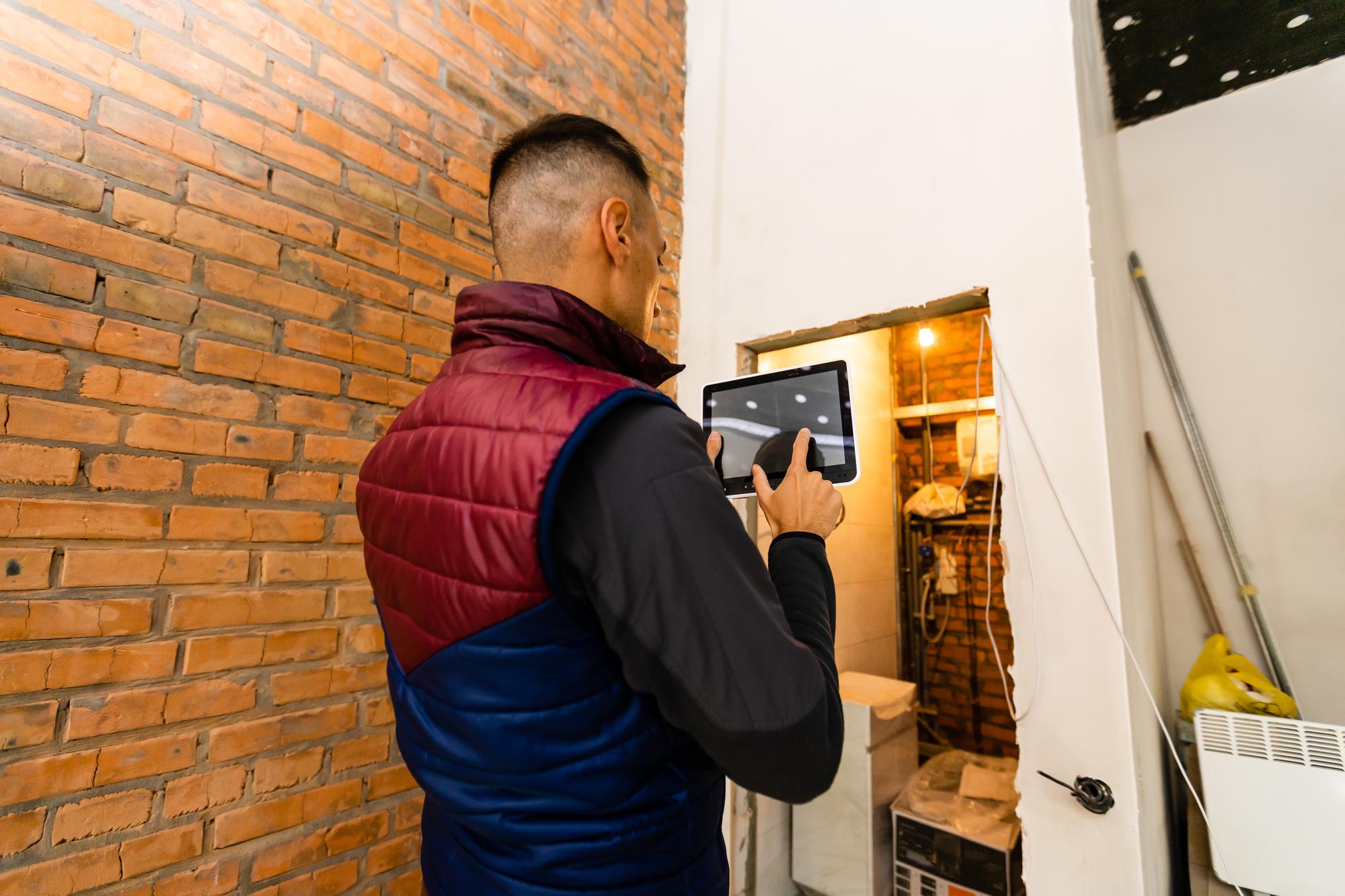 Reparação, construção e conceito de construção - trabalhador sorridente feliz ou construtor com computador tablet pc e ferramentas sobre construção