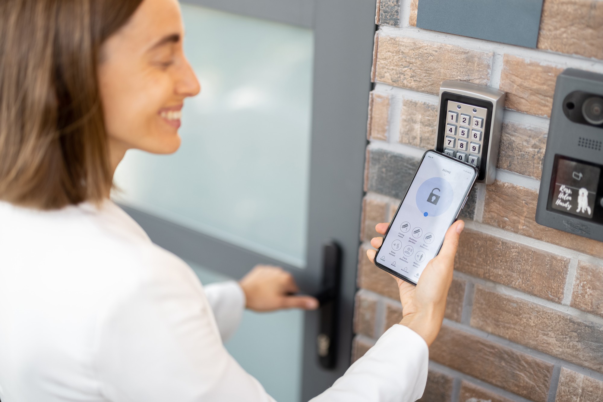 Mulher coloca o smartphone no leitor eletrônico para acessar o apartamento ou o escritório. Célula com execução de aplicativo seguro para celular