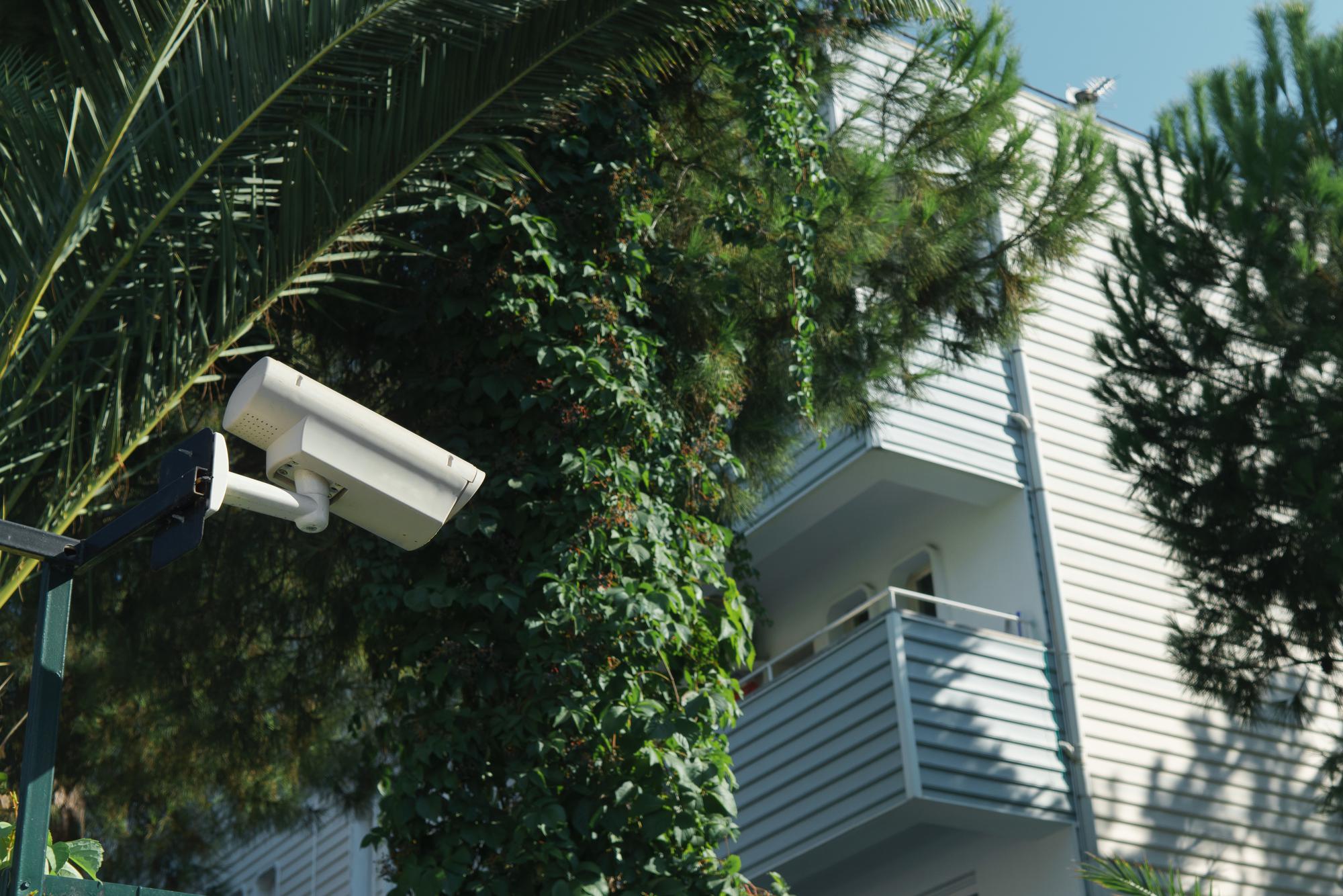 Câmera de CCTV ao ar livre no dia ensolarado no fundo da casa com varandas