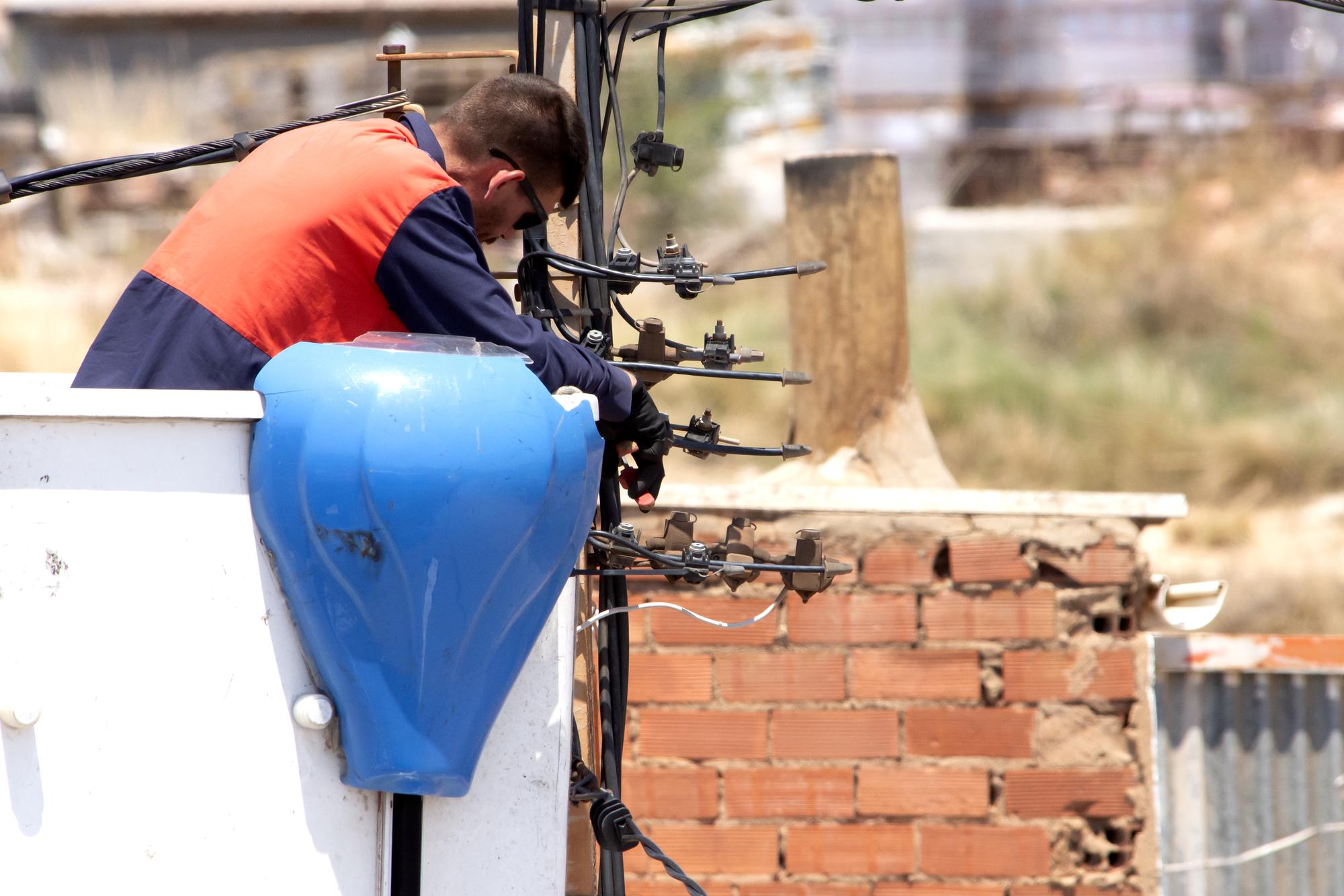 Um eletricista realiza manutenção em linhas elétricas usa equipamentos de proteção e ferramentas de um elevador