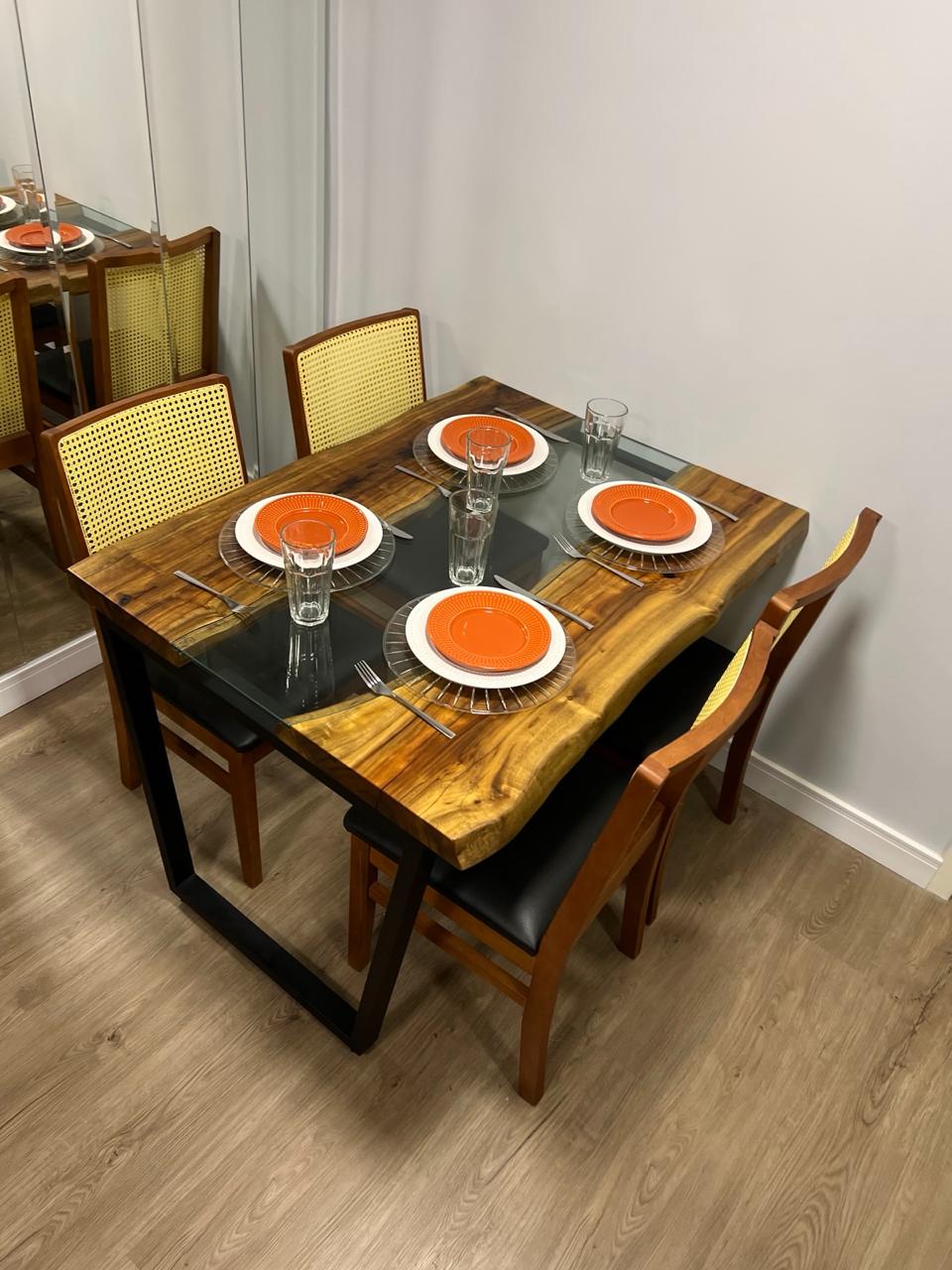 Sala de jantar de apartamento moderno com uma mesa de madeira maciça Arwo de bordas orgânicas e cadeiras de design contemporâneo