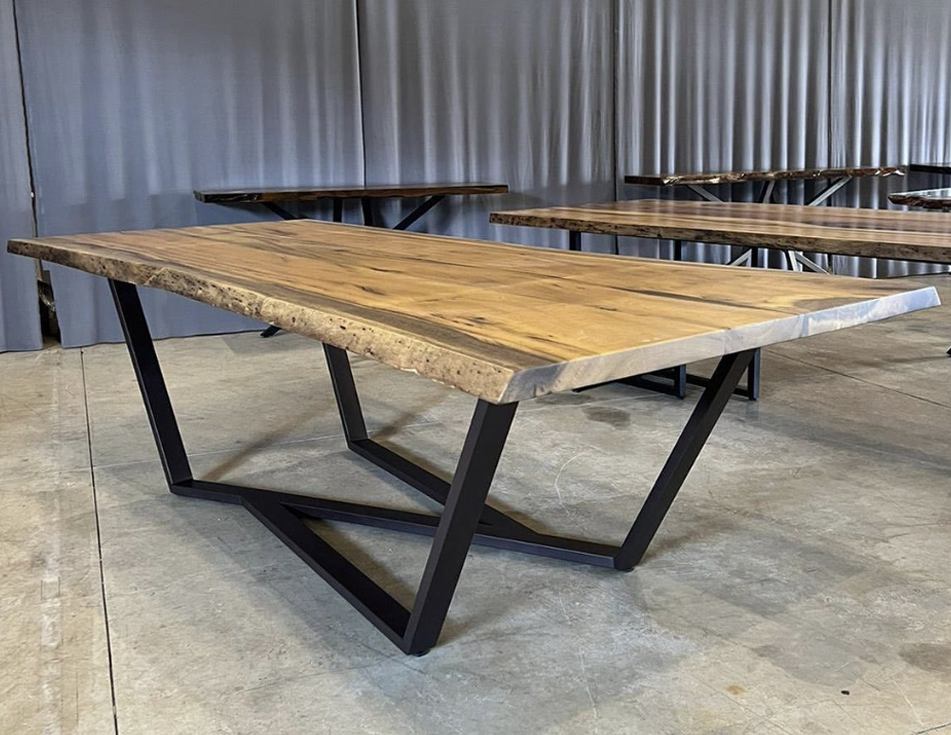 Detalhe aproximado de uma mesa de madeira maciça mostrando os veios naturais, nós e o acabamento acetinado de alta qualidade