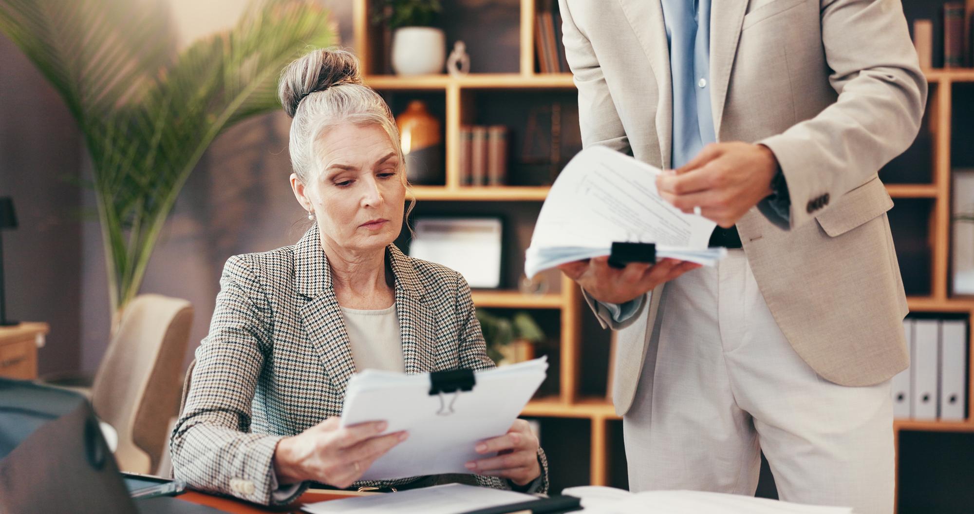 Woman lawyer and meeting with paperwork in office for legal consulting review contact and company case Mature client attorney and documents for settlement information and procedure of management