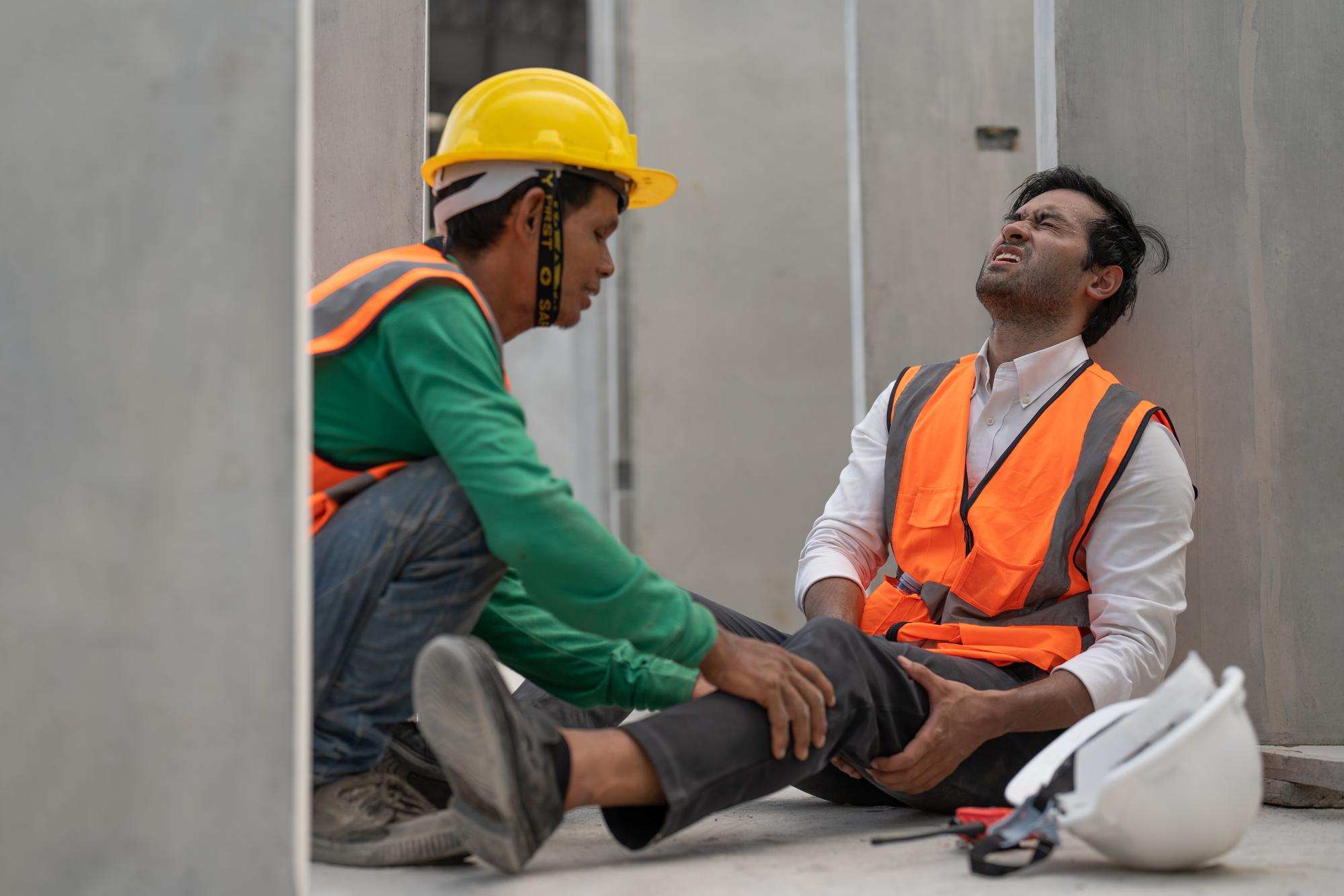 Um engenheiro asiático sente dor na perna por causa de um acidente enquanto trabalhava em um canteiro de obras