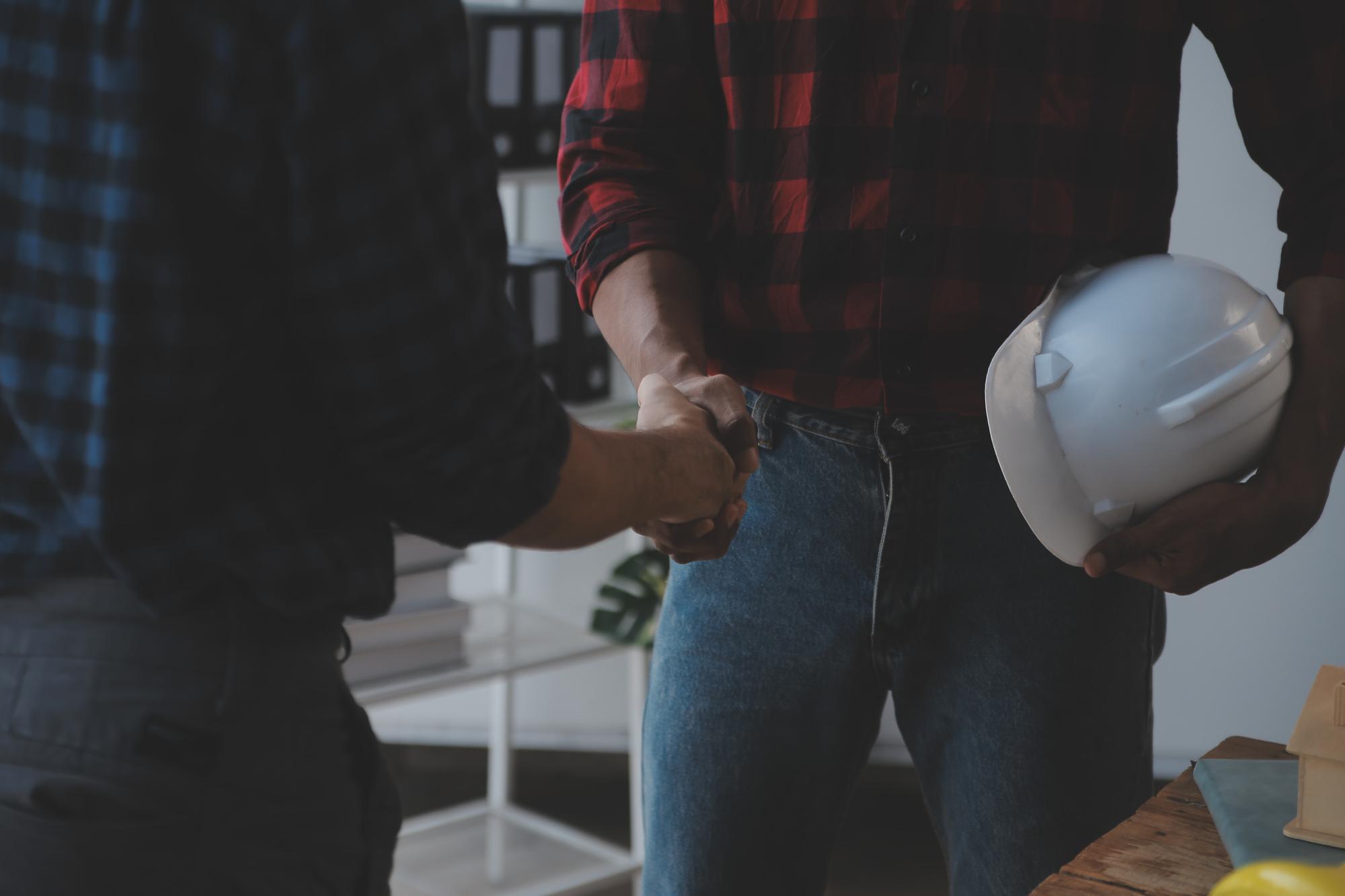 Close-up de um engenheiro civil asiático trabalhando em um projeto arquitetônico no canteiro de obras na mesa do escritório