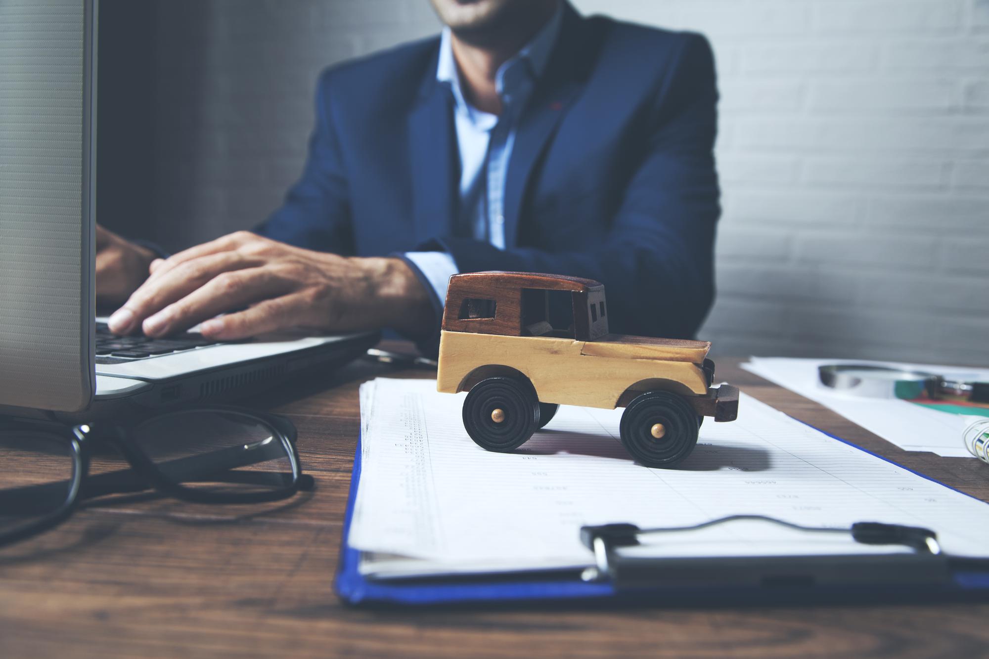 Homem trabalhando no computador com carro