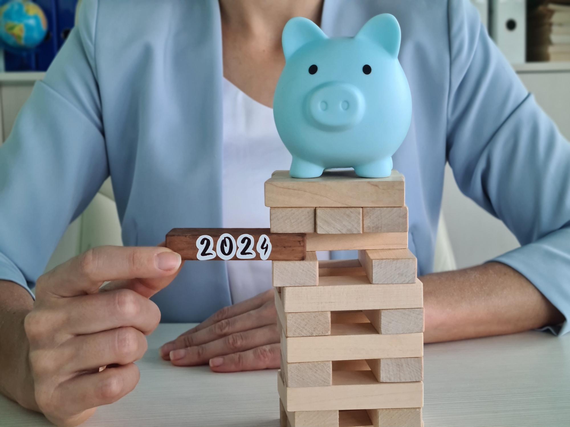 Piggy bank com pedaços de blocos caindo e 2024