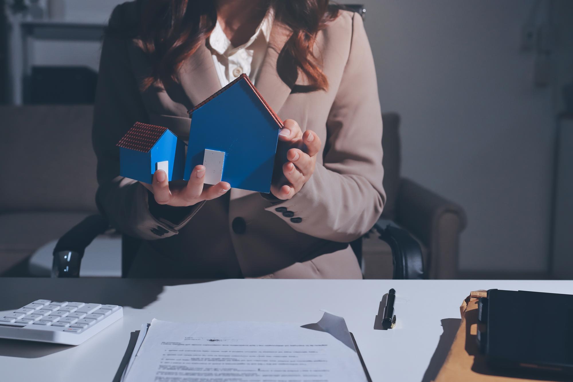 Corredora imobiliária feminina apresentando e aconselhando xDmodelo de casa e detalhe do projeto de construção no escritório assina contratos de compra e venda relativos à oferta de empréstimo hipotecário e seguro xD