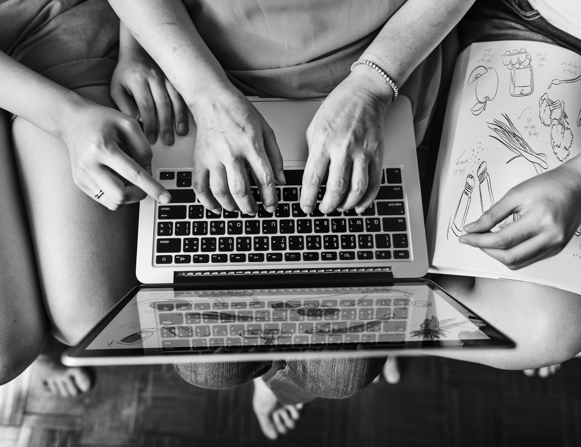 Equipe de tecnologia e marketing colaborando em volta de uma mesa com designs de interfaces web modernos e minimalistas