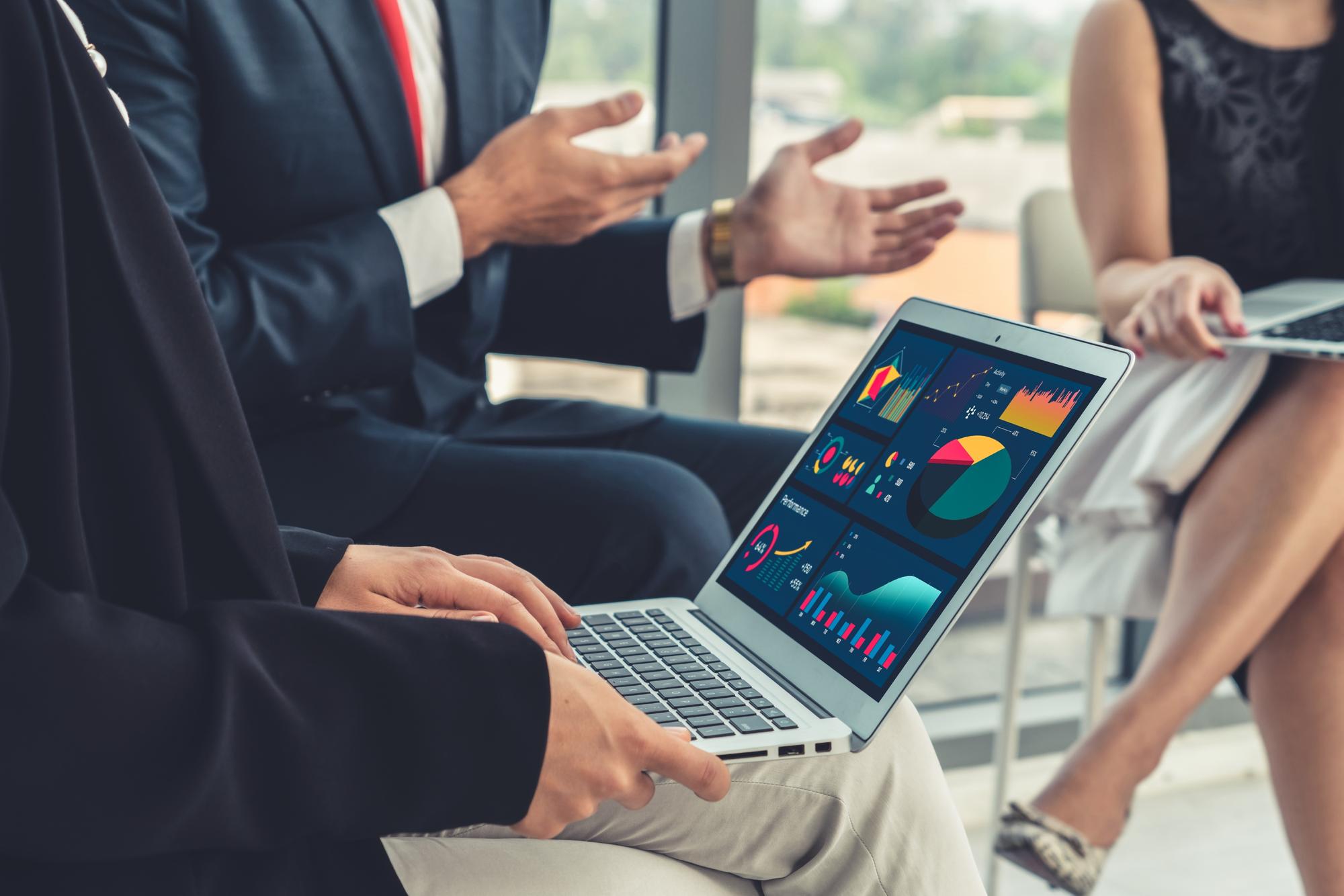 Equipe de marketing analisando métricas de performance e dashboards de dados em um ambiente corporativo moderno