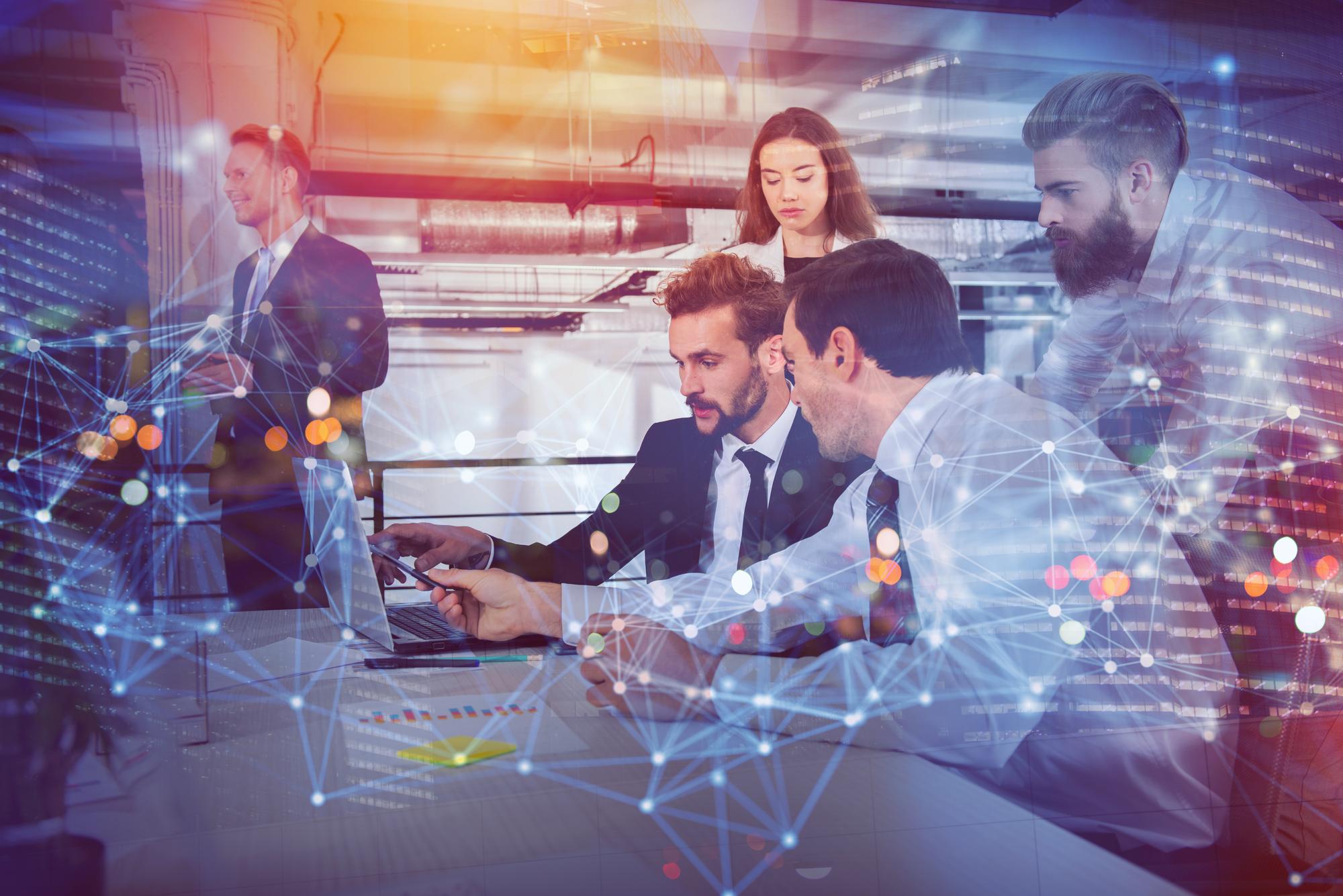 Equipe de tecnologia e marketing colaborando em frente a uma tela com código e design de interface