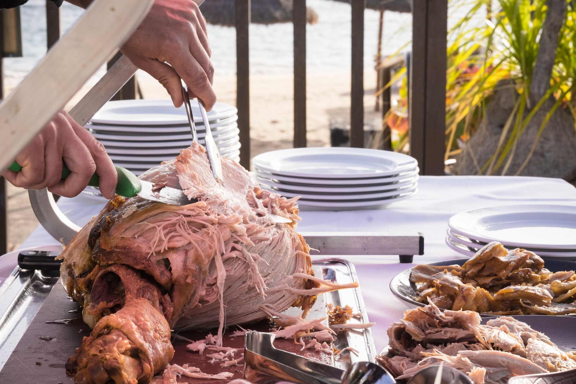 Celebração ao ar livre com conceito de restaurante ou serviço de bufê e chef cortando e servindo um peru grande e saboroso