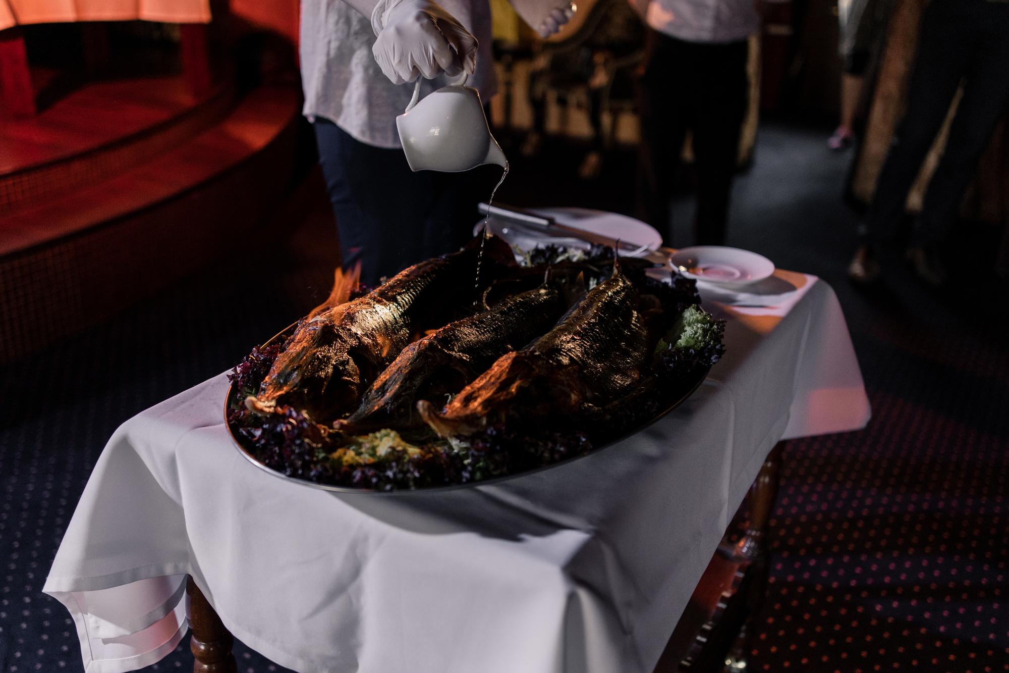Um grande pedaço de carne frita em chamas no cozinheiro do restaurante