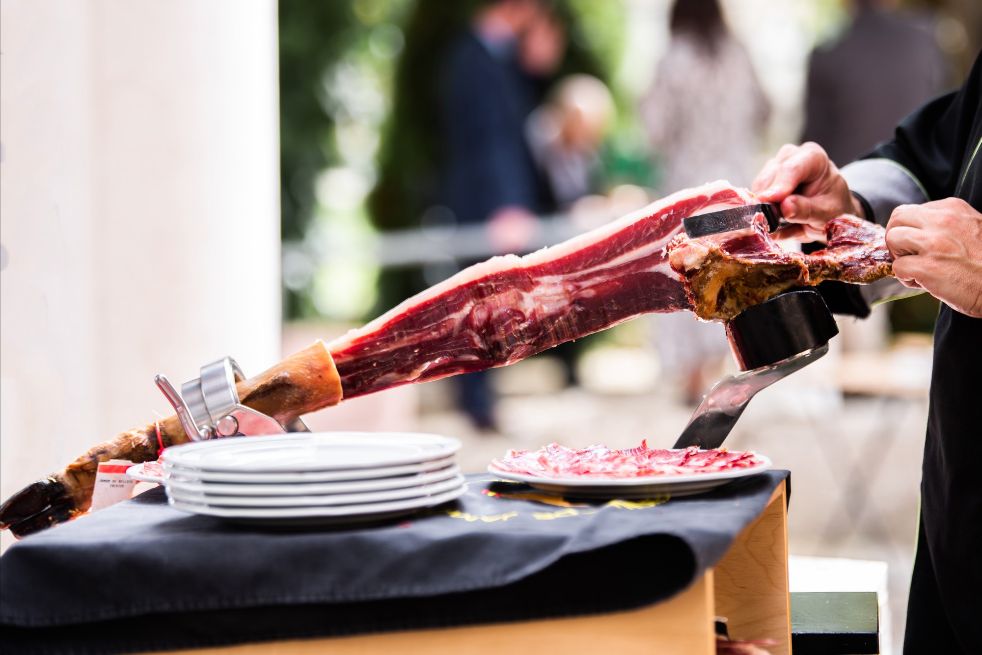 Um cortador de presunto ibérico cortando fatias de perna de presunto em um evento