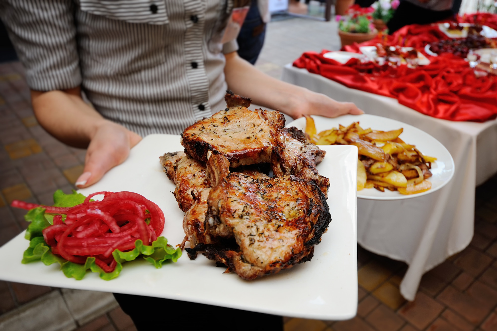 O garçom traz bife frito e batatas