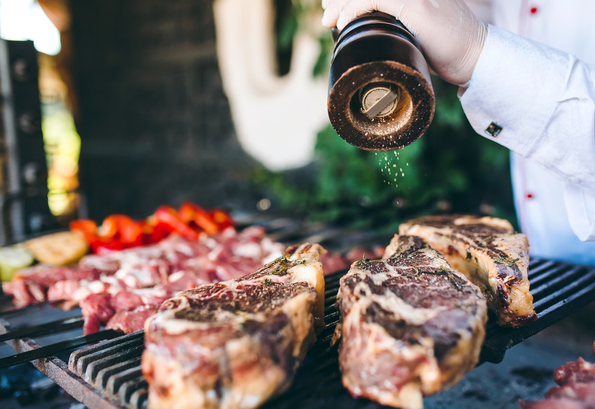 O chef prepara carne no churrasco.