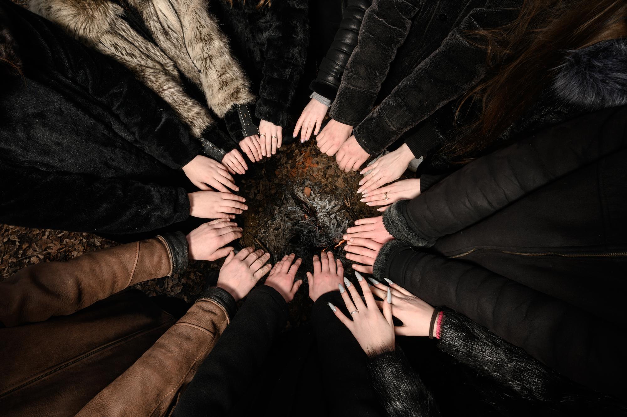 as mãos das crianças são dobradas com as palmas das mãos em um círculo as mãos são mantidas sobre o fogo