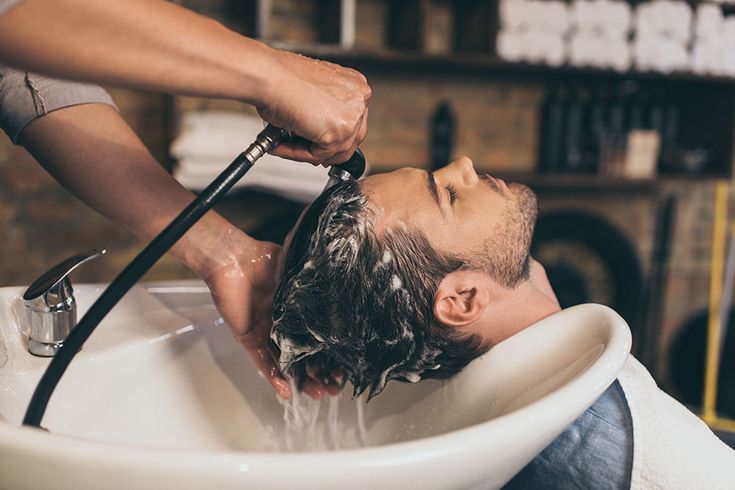 Executivo relaxando em cadeira de massagem de uma barbearia de alto padrão com toalha quente no rosto