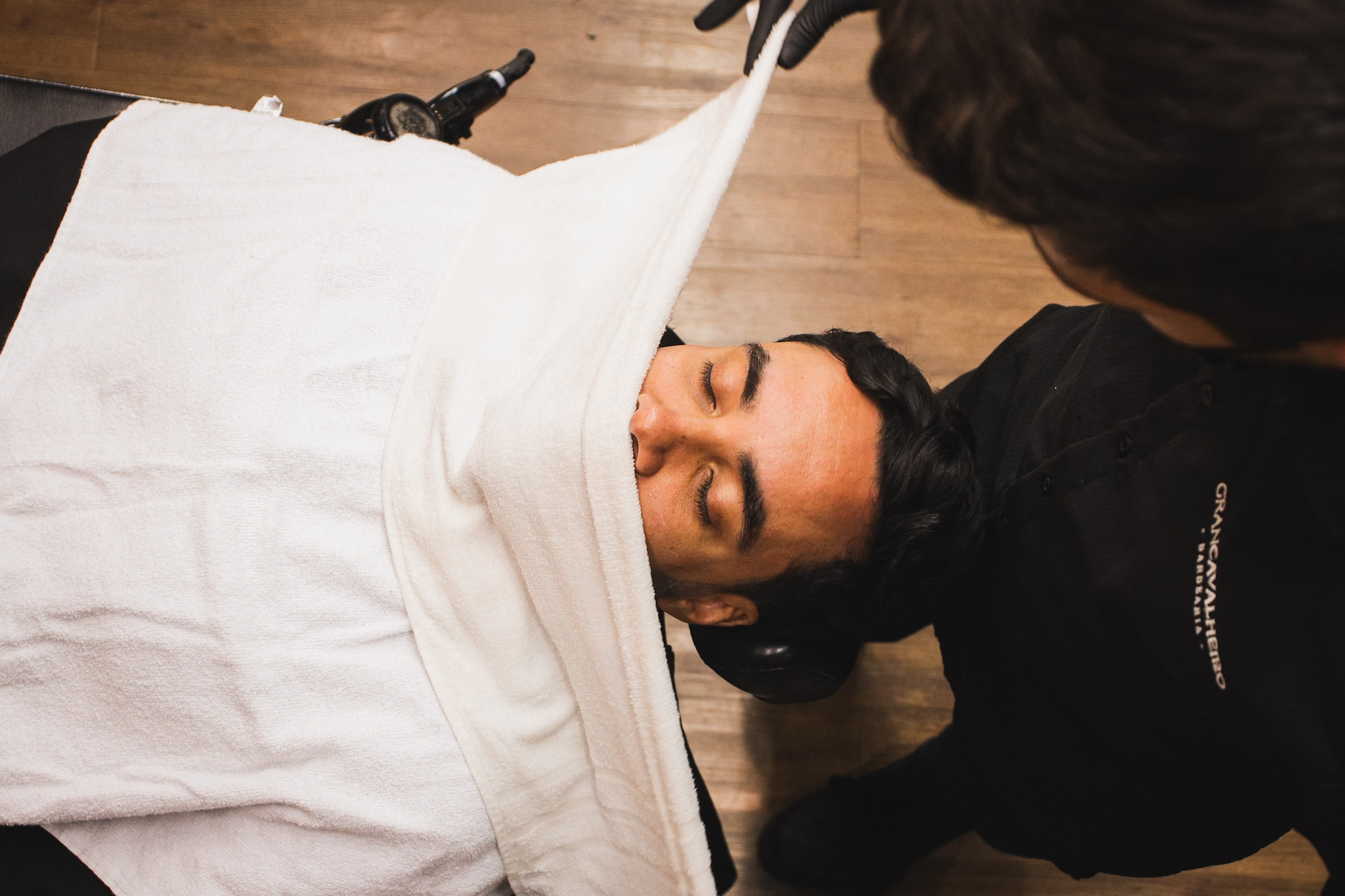 Detalhe de produtos renomados como Keune 1922 sobre bancada de mármore em barbearia premium