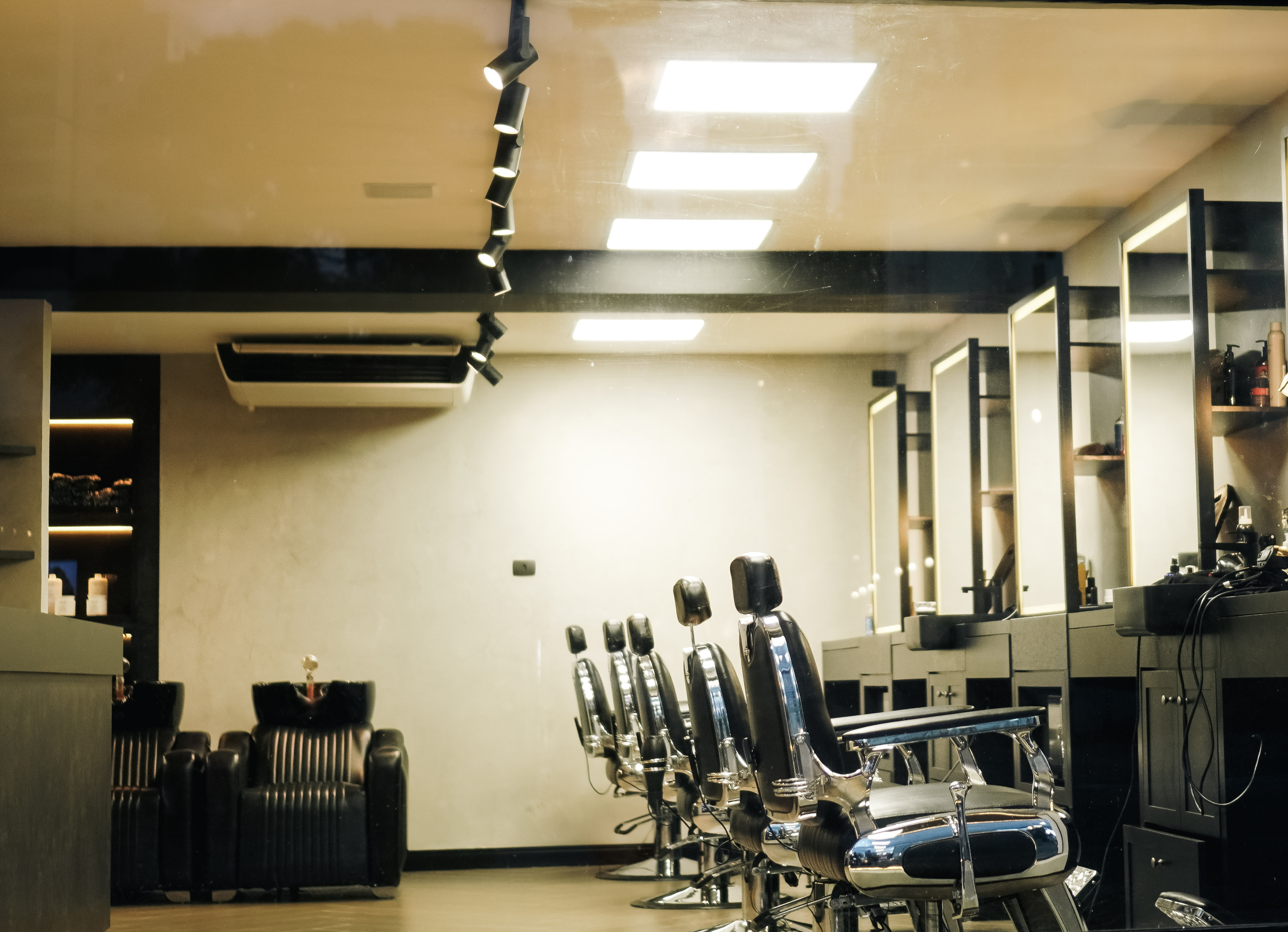 Detalhe de mãos profissionais utilizando produtos premium Keune em um procedimento de barba masculina