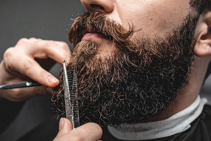 Close focado na precisão do corte de barba em ambiente sofisticado e minimalista