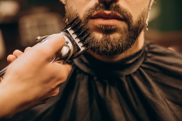 Ambiente de barbearia luxuosa em Curitiba com tons de madeira escura, sofás de couro e iluminação sofisticada