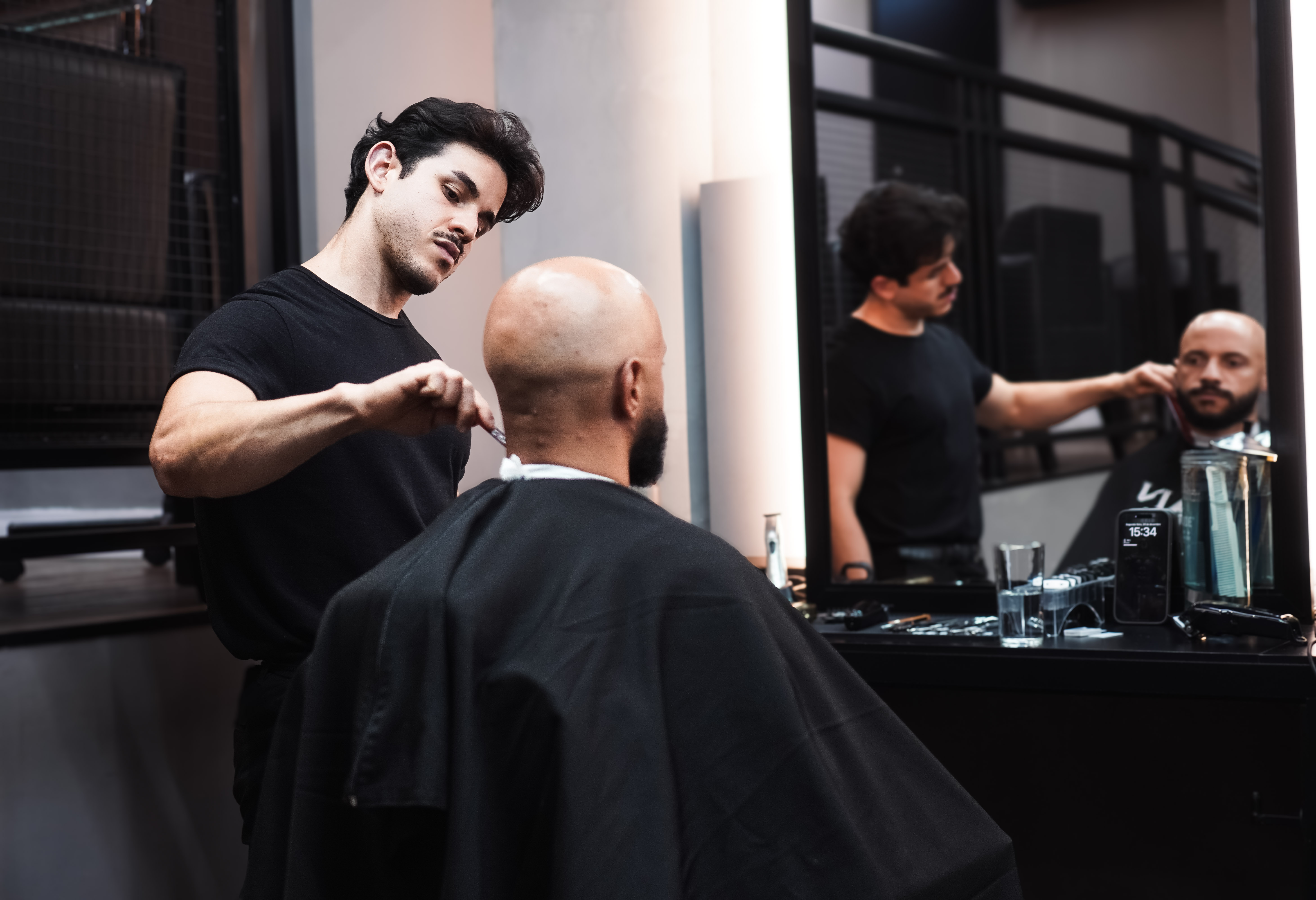 Homem de negócios em ambiente premium de barbearia recebendo atendimento de excelência com foco em detalhes de acabamento
