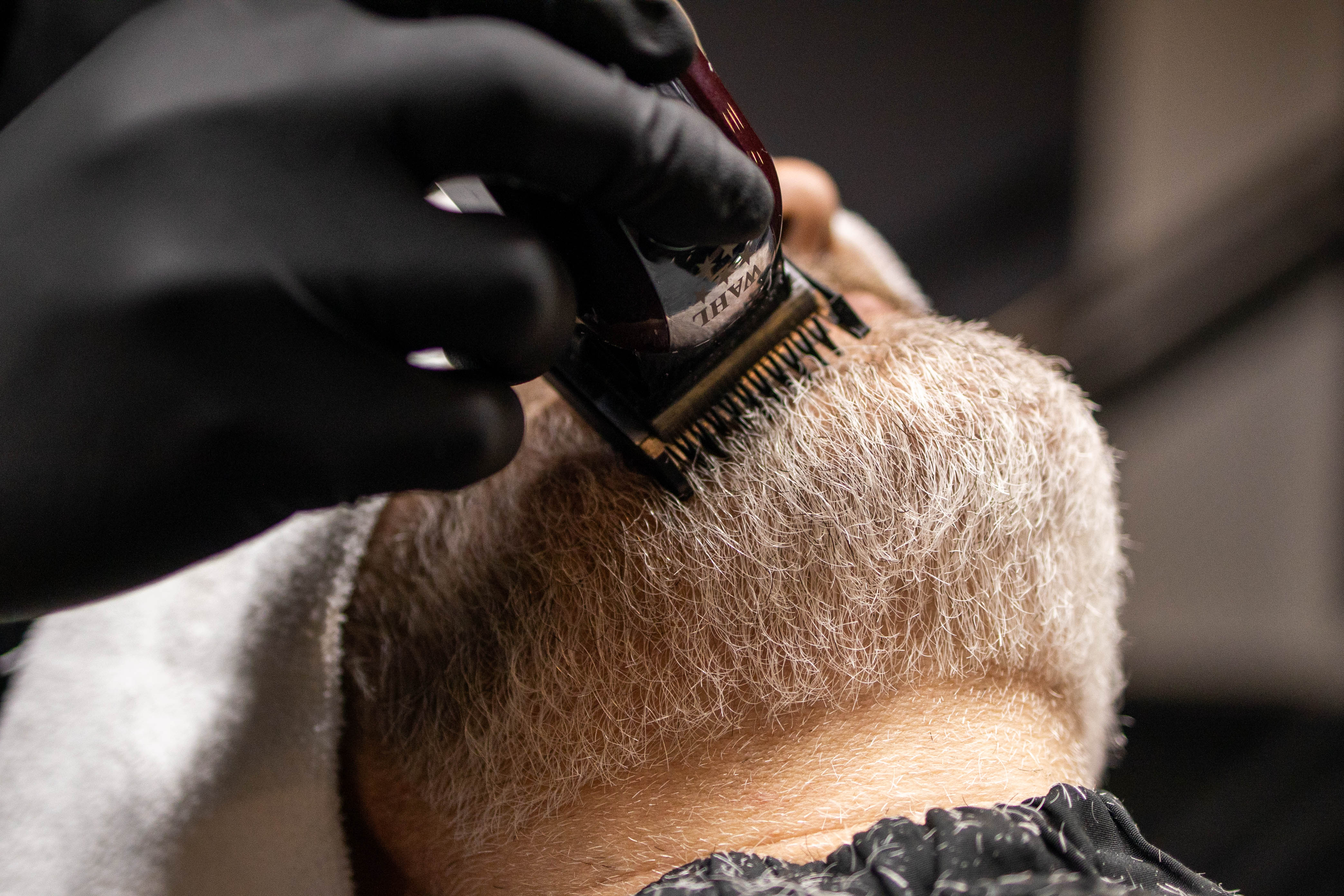Executivo elegante em ambiente de barbearia premium com tons de roxo e iluminação sofisticada