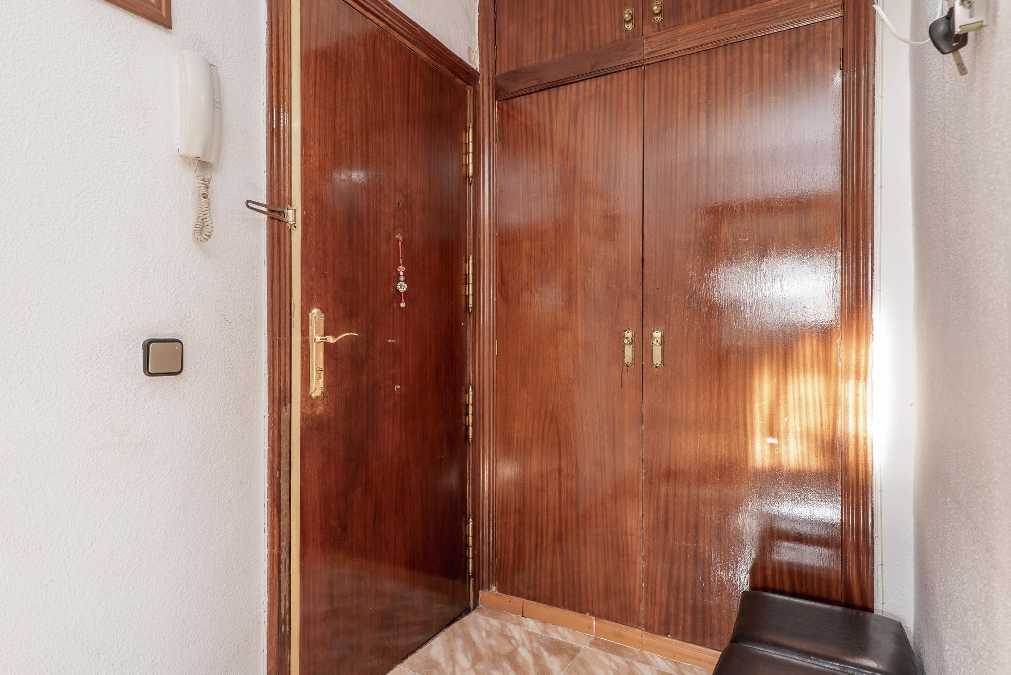Hall de casa com porta blindada e roupeiro embutido em madeira sapele envernizada a combinar