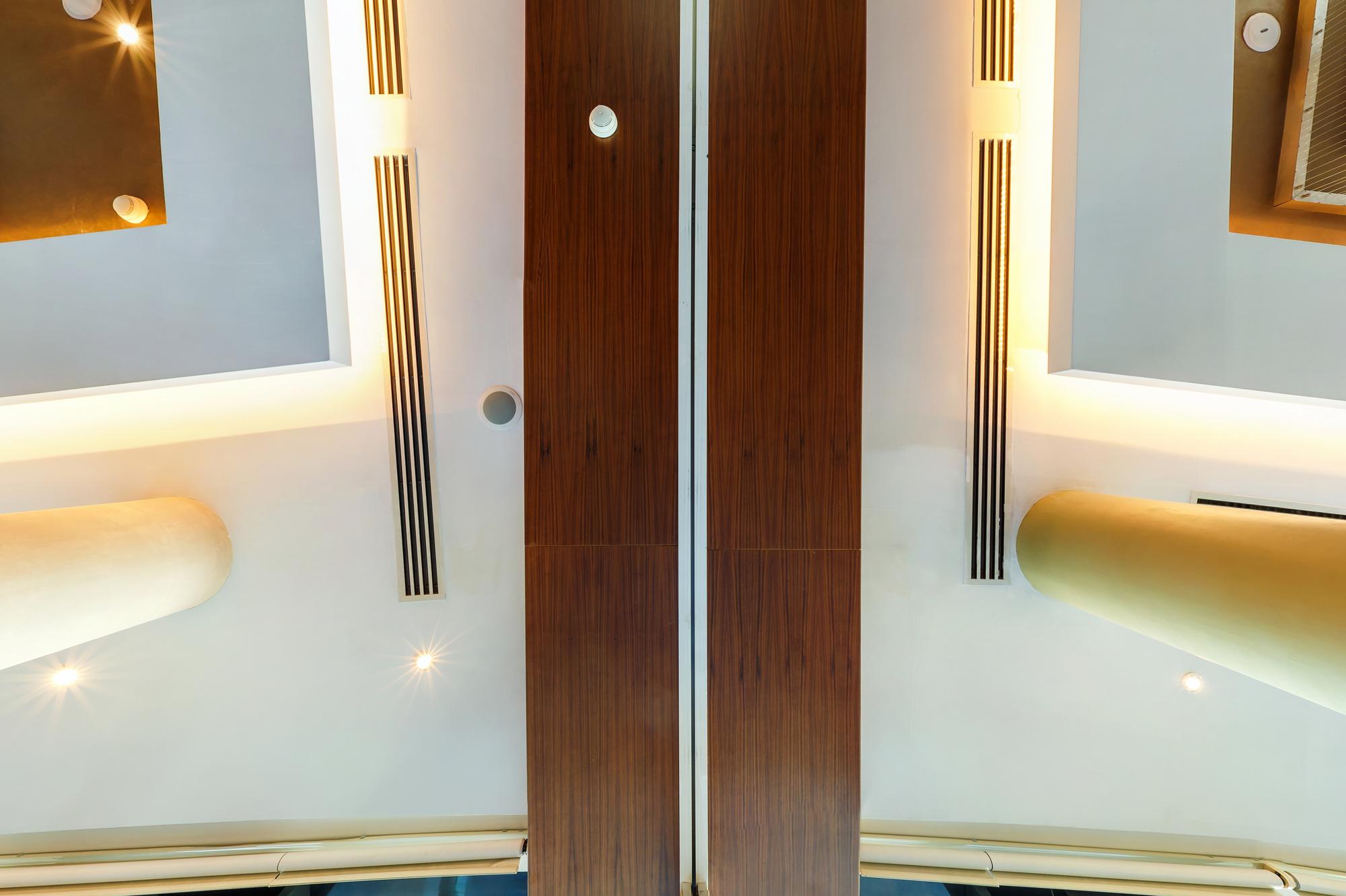 Sala de estar sofisticada com grandes portas laqueadas de duas folhas integrando ambientes