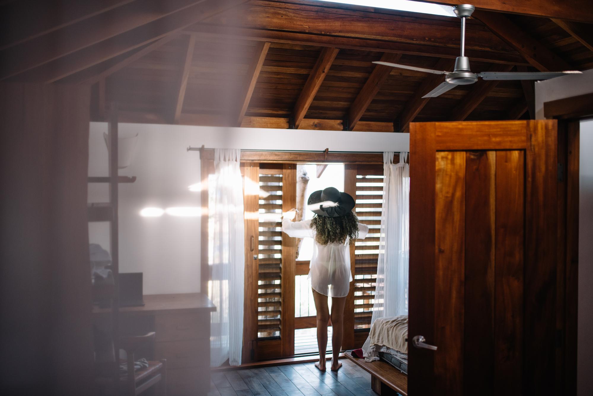 Vista traseira de uma mulher de pé em casa