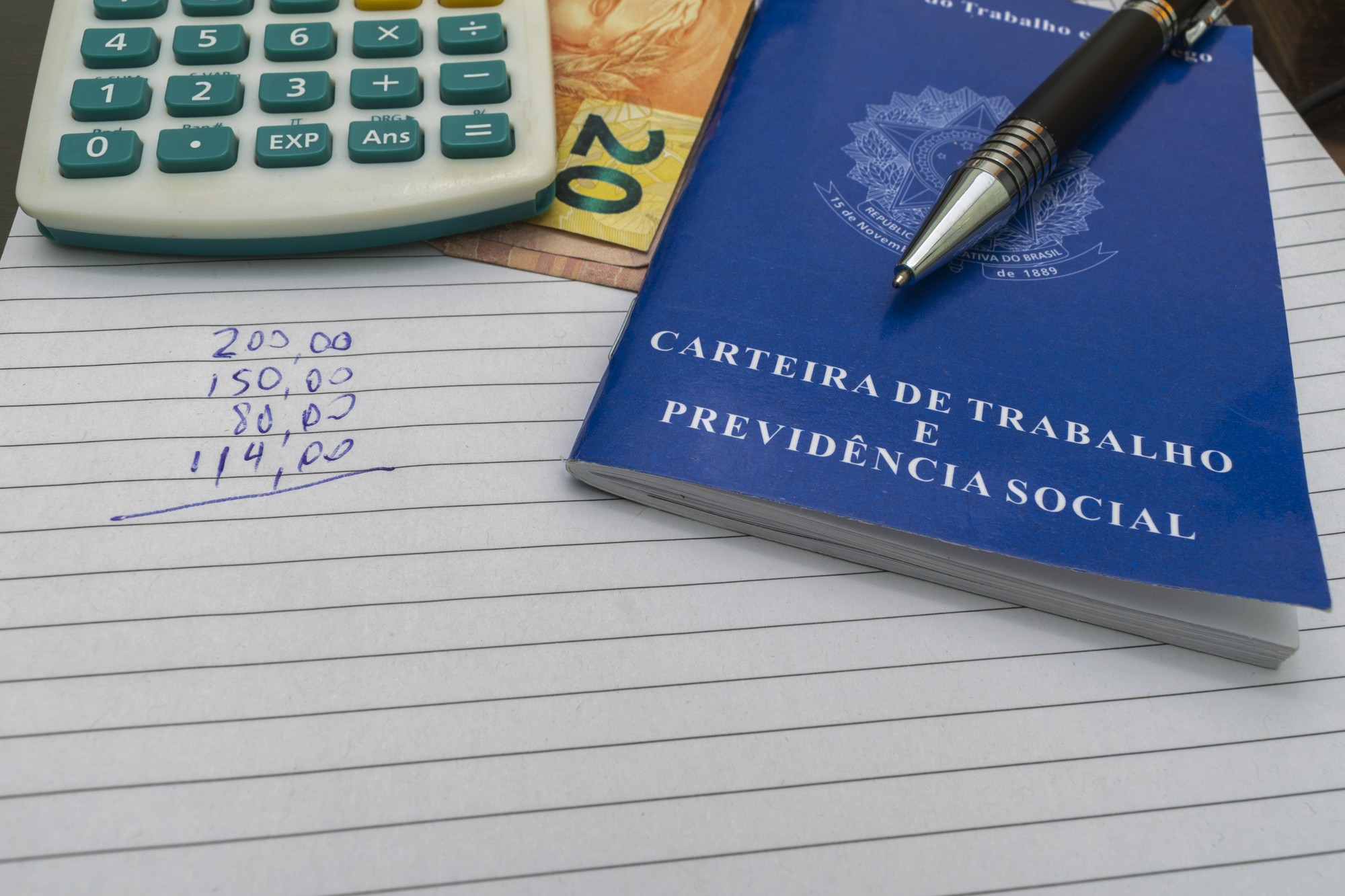 Cartão de Trabalho Brasileiro com calculadora, caneta e papel com números. Conceito de controle financeiro.