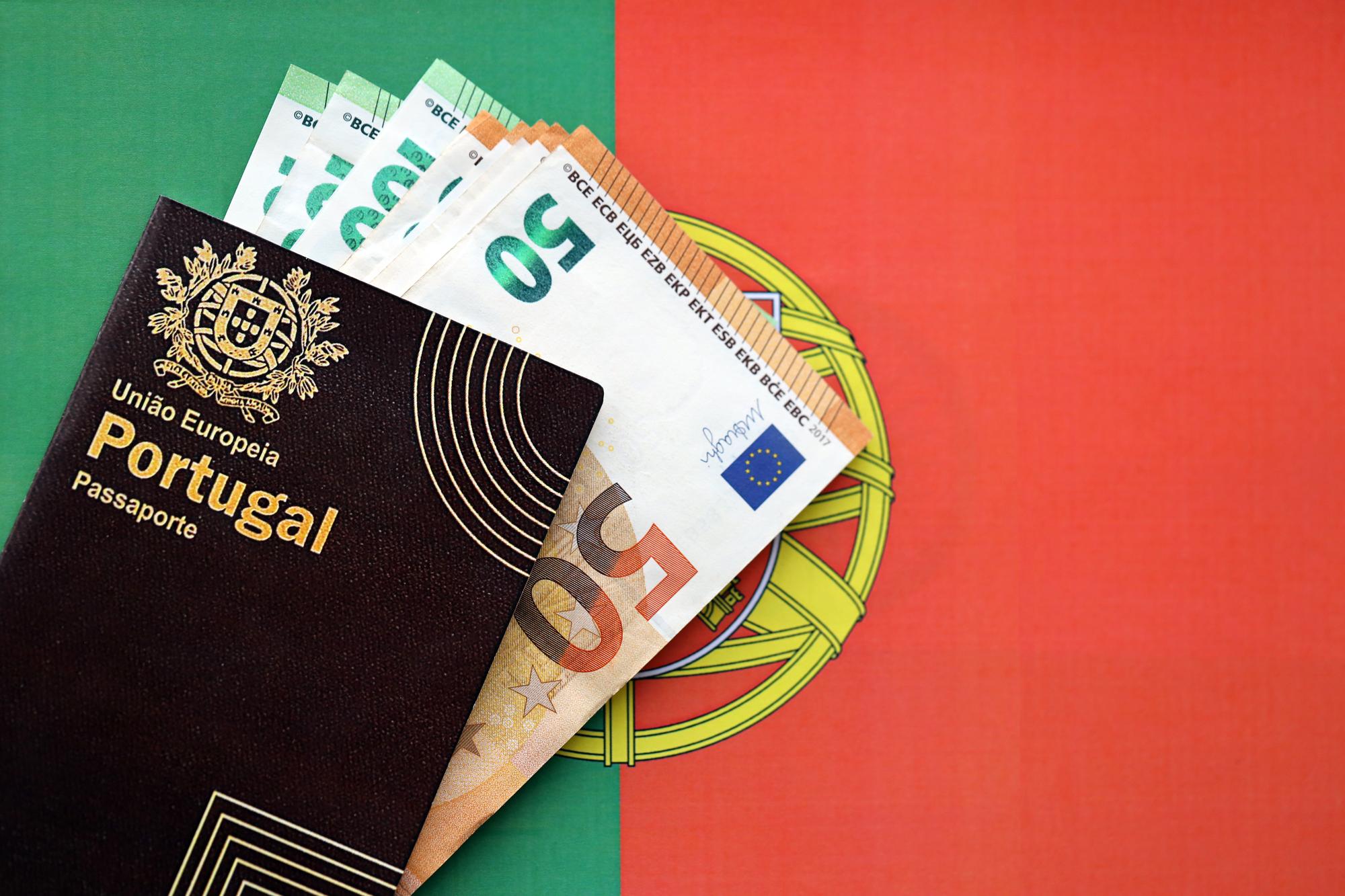Passaporte português vermelho da União Europeia e dinheiro em fundo de bandeira em close-up