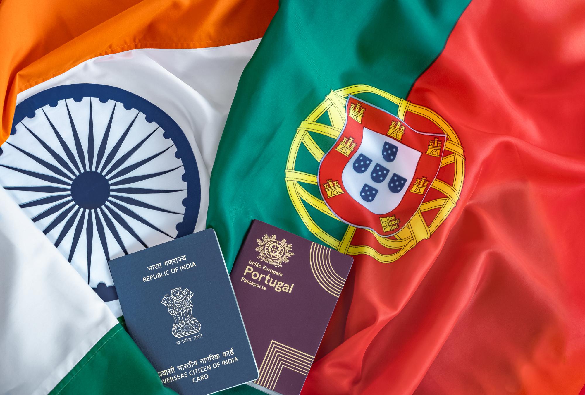Cartão OCI e passaporte português sobre fundo de bandeira indiana e bandeira portuguesa