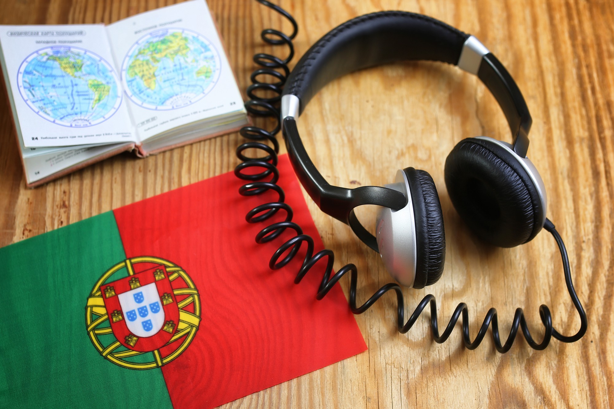 Fone de ouvido do curso de idiomas e bandeira na mesa de madeira