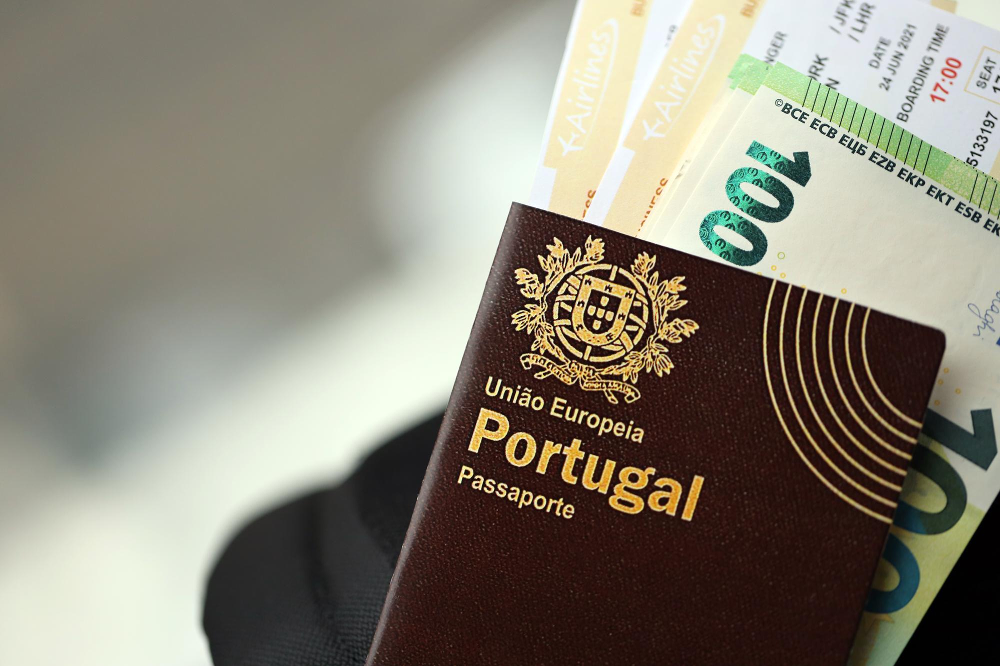 Passaporte português vermelho da União Europeia com dinheiro e bilhetes de avião em mochila turística